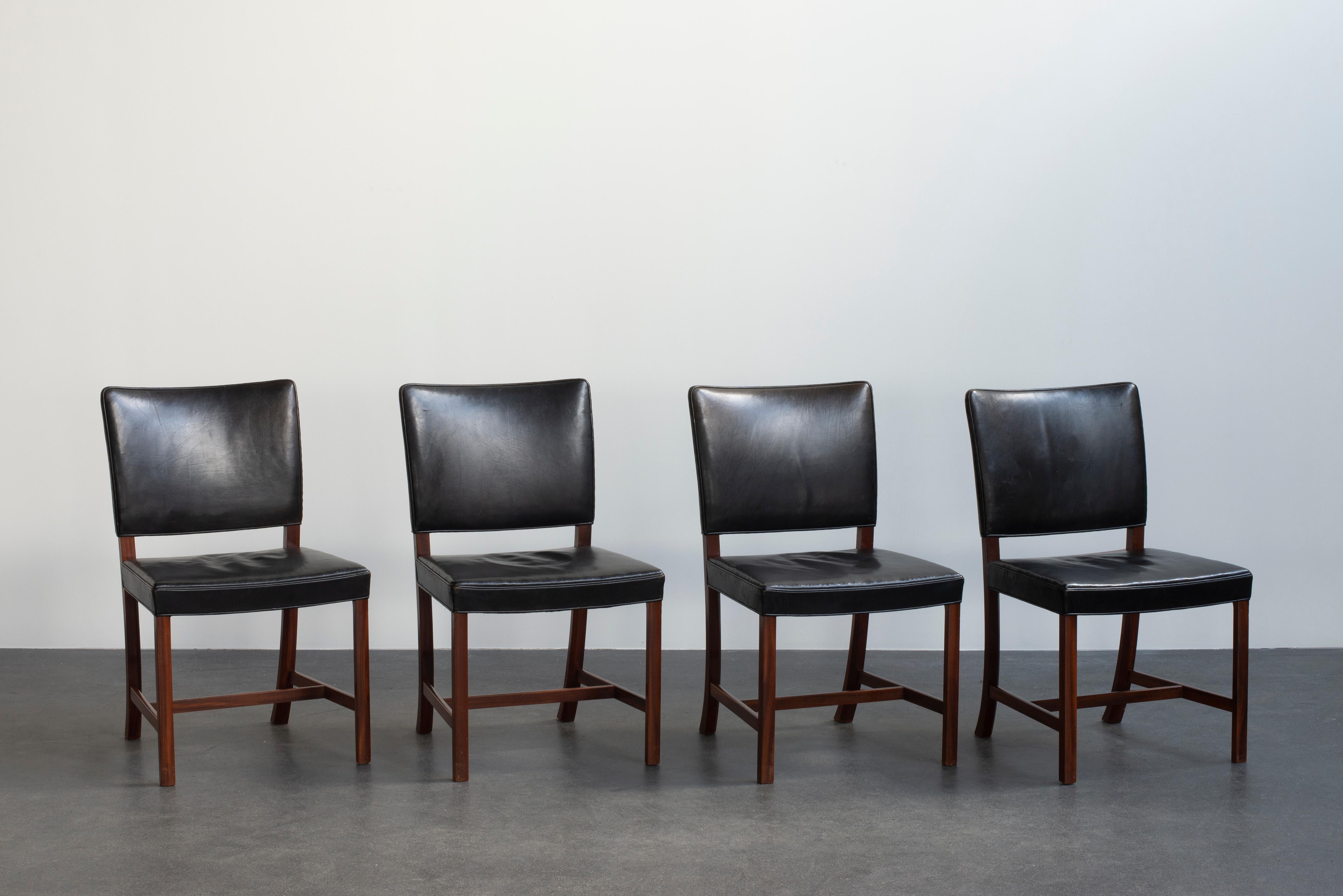 Ole Wanscher set of for chairs in mahogany and black leather. Executed by A. J. Iversen, Copenhagen, Denmark.