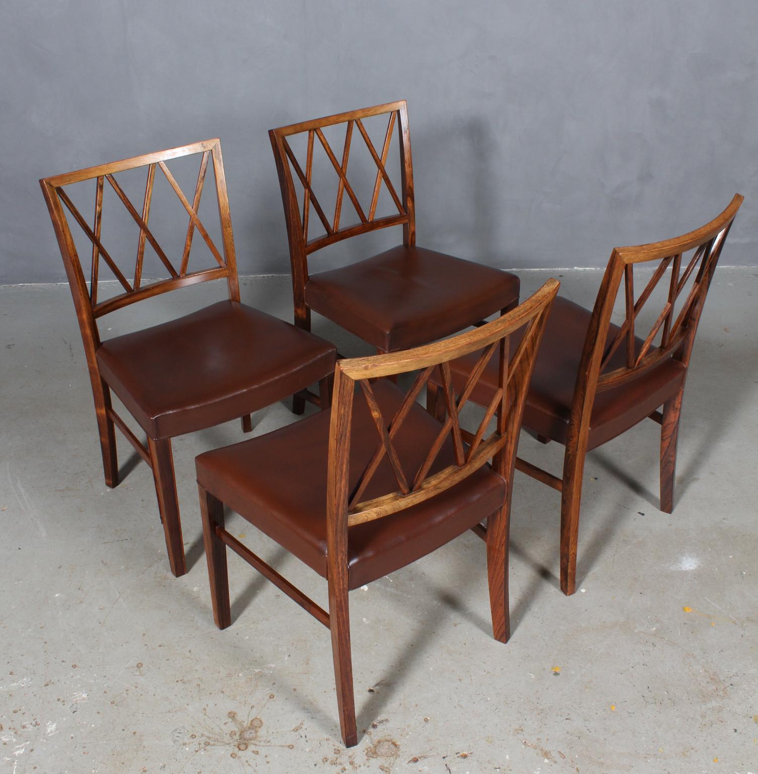Ole Wanscher set of four dining chairs, upholstered with patinated brown aniline leather.

Made of rosewood, profilated legs.

Made of Slagelse Møbelværk.