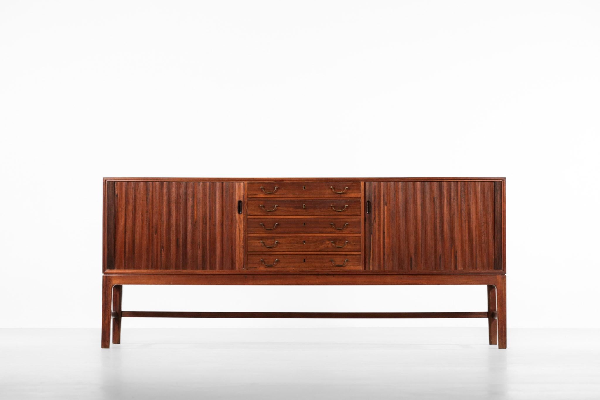 Rare sideboard designed by Ole Wanscher.
Structure in rosewood with brass knobs.
Composed of two sliding doors with 5 drawers.
High quality work.