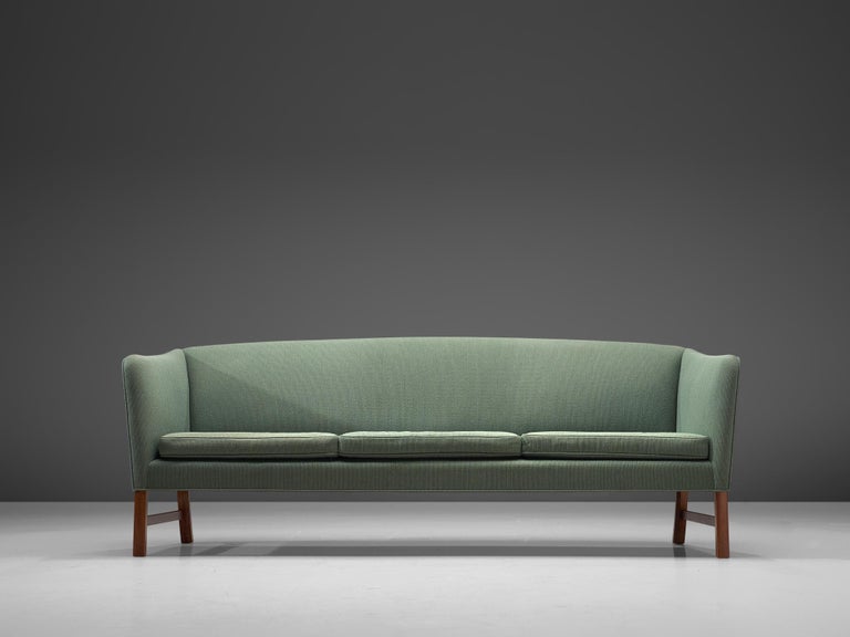 Ole Wanscher for A.J. Iversen, three-seat sofa, in mahogany and soft green fabric, Denmark, 1950s. 

This sofa is designed by Ole Wanscher for A.J. Iversen in the 1950s. Typical Danish design traits are shown, such as exquisite craftsmanship and