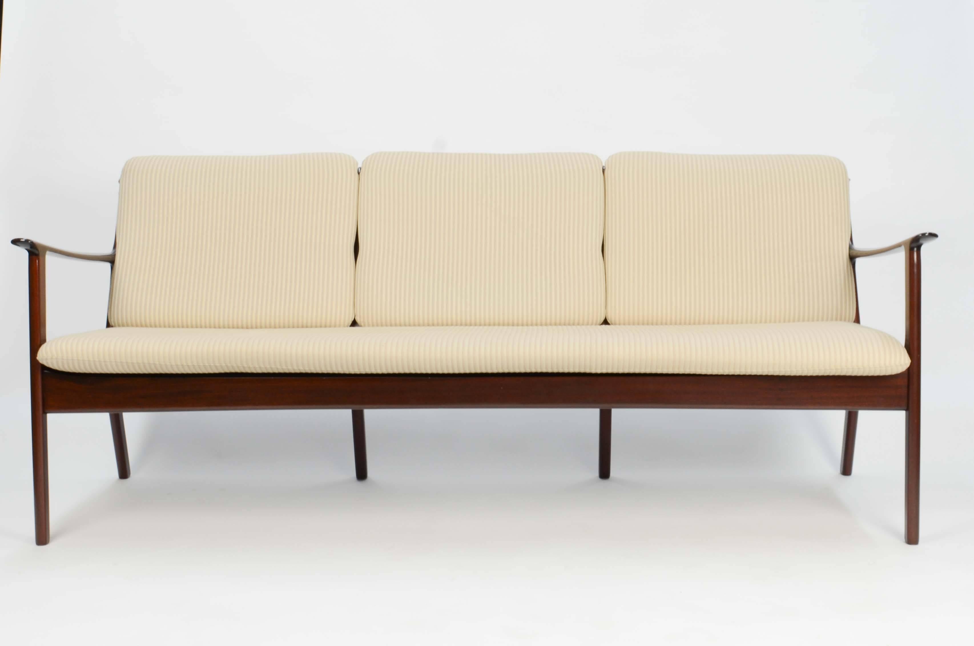 Ole Wanscher's sofa JP112 for P. Jeppesens Møbelfabrik of Denmark in Mahogany. The three-seat sofa features the detailed design of the farther of Danish modern movement.
