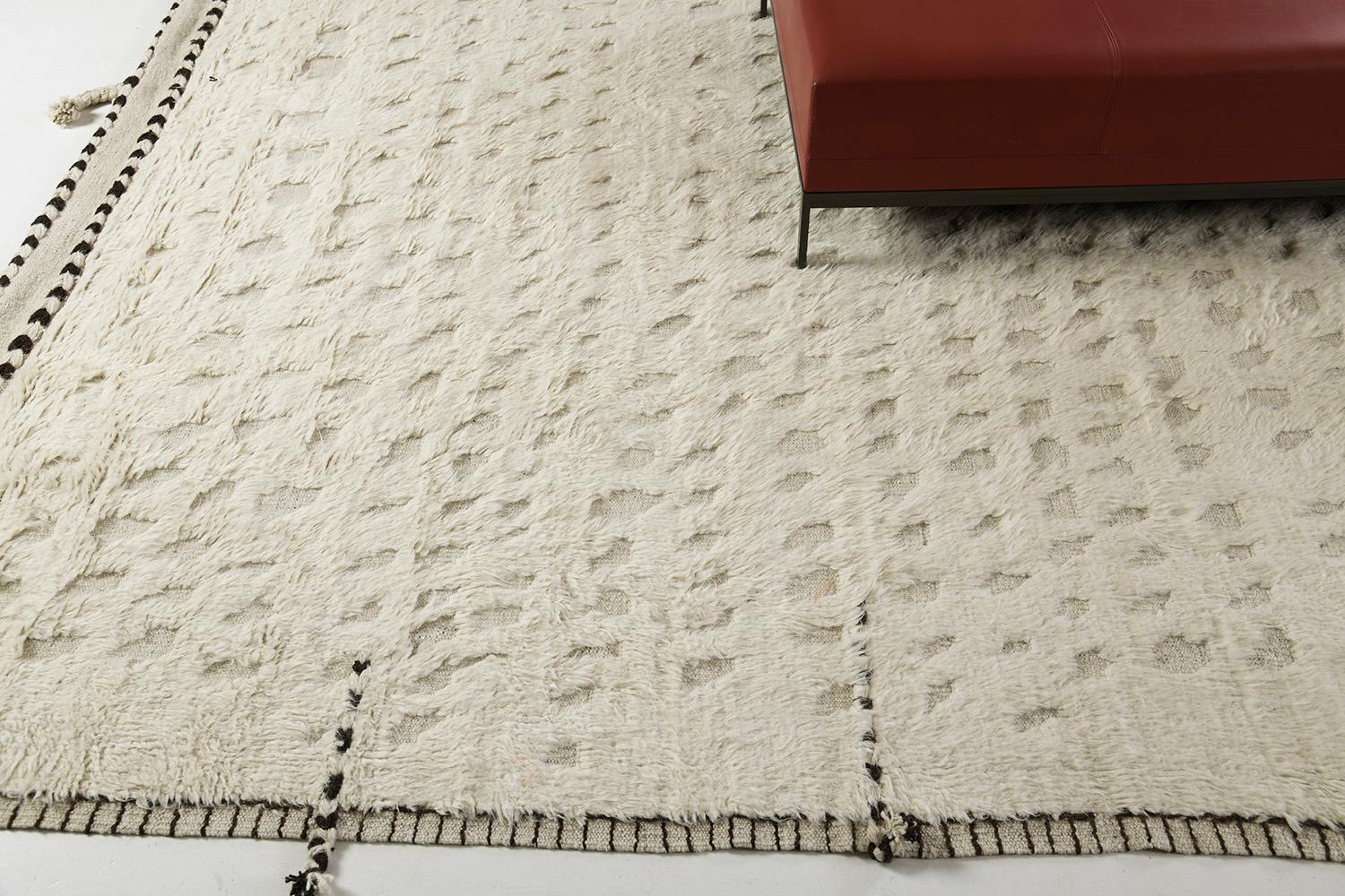 Olea' is a hand-knotted wool shag rug built on a flat-weave base. Tassel detailing run along the sides with dark stitch marks. This playful piece has a perfectly white foundation with round embossed details filling in the space and playing with the