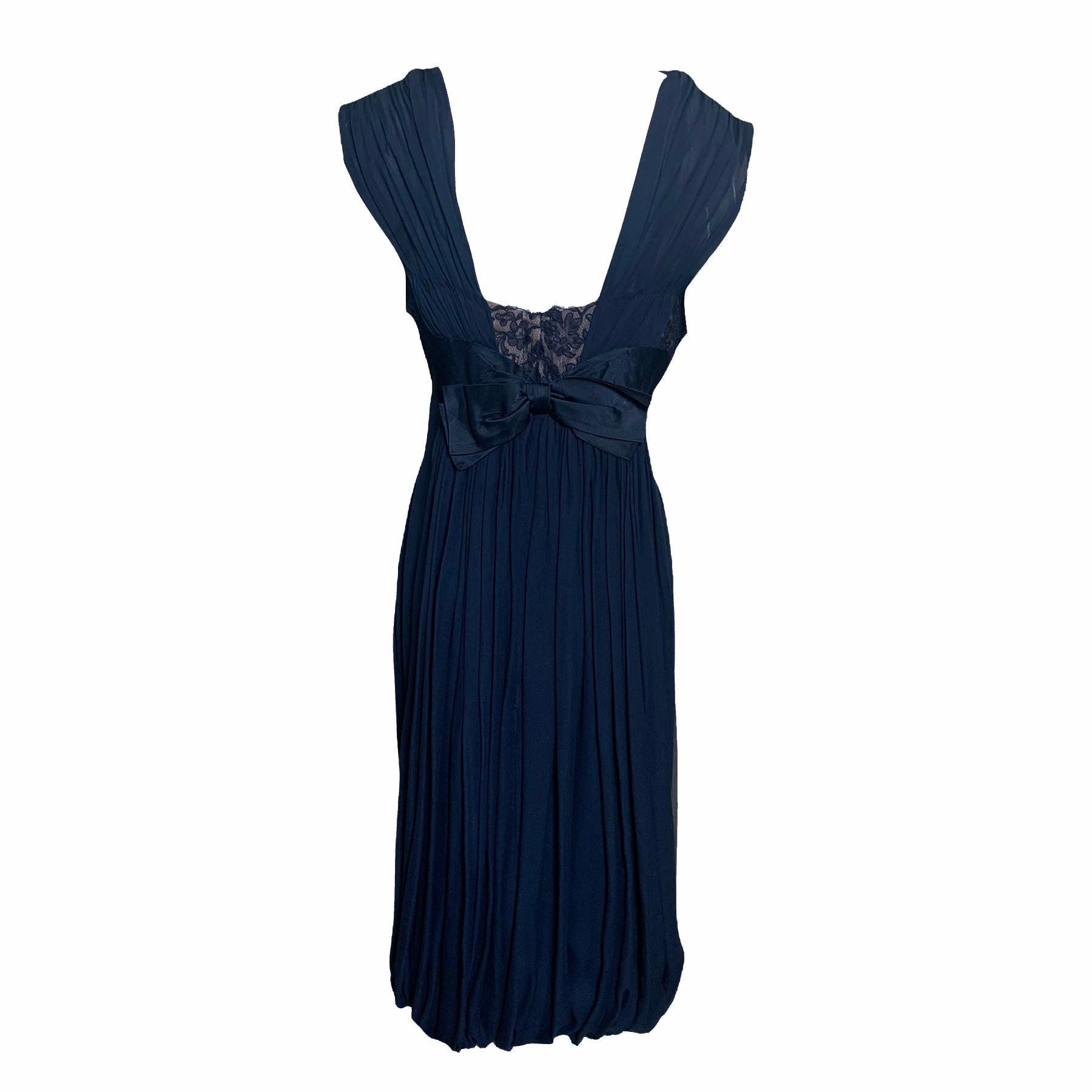 Label-less Oleg Cassini cocktail in deep royal blue silk chiffon. Empire waist with satin band and lace insert at bust with nude underlay. Boned and lined bodice with swagged neckline. Draped skirt with bubble hem at back. Excellent