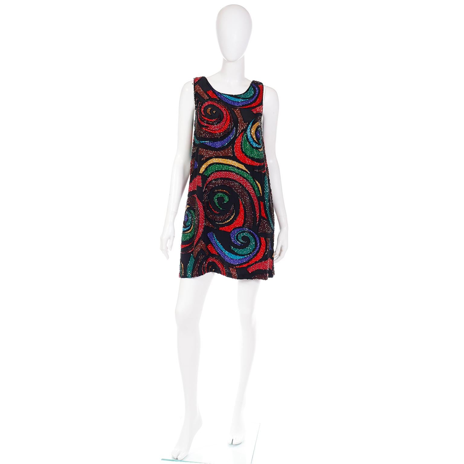 This is a fun vintage dress from Oleg Cassini for Black Tie that is covered in bugle beads that define a multi colored swirl pattern print in shades of blue, red, purple, pink, yellow and black.. There is a center back zipper for closure and the