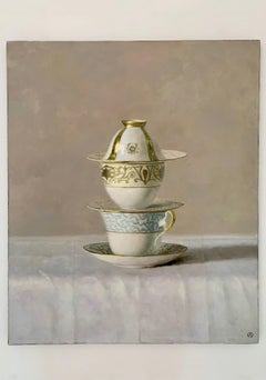 Nature morte de tasses blanches, bleues et or, empilées sur un fond beige".