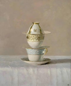Nature morte de tasses blanches, bleues et or, empilées sur un fond beige".