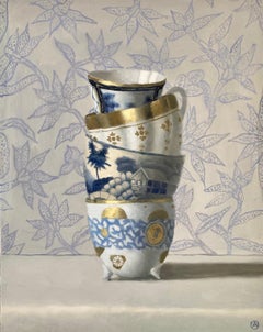 "Four Stacked Blue, White, and Gold Cups on Ground with Lavender Flowers"