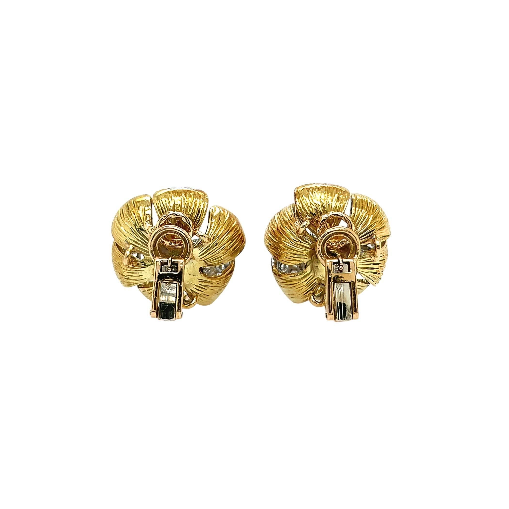 A pair of 18 karat yellow gold, platinum and diamond earclips, Olga Tritt.  Each gold earclip designed as a flower with six incurling textured petals, three petals enhanced with approximately 17 platinum set round brilliant cut diamonds, the flower