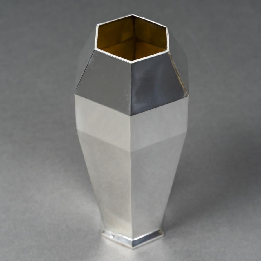 Solid silver vase with hexagonal shape, ovoid with six cut sides, plain body, interior in vermeil.

Dimensions: height 20 cm - width at the belly 10 cm - diameter of neck and base 5.5 cm

Material: Solid silver 1st title 950/°°°

Weight: 376