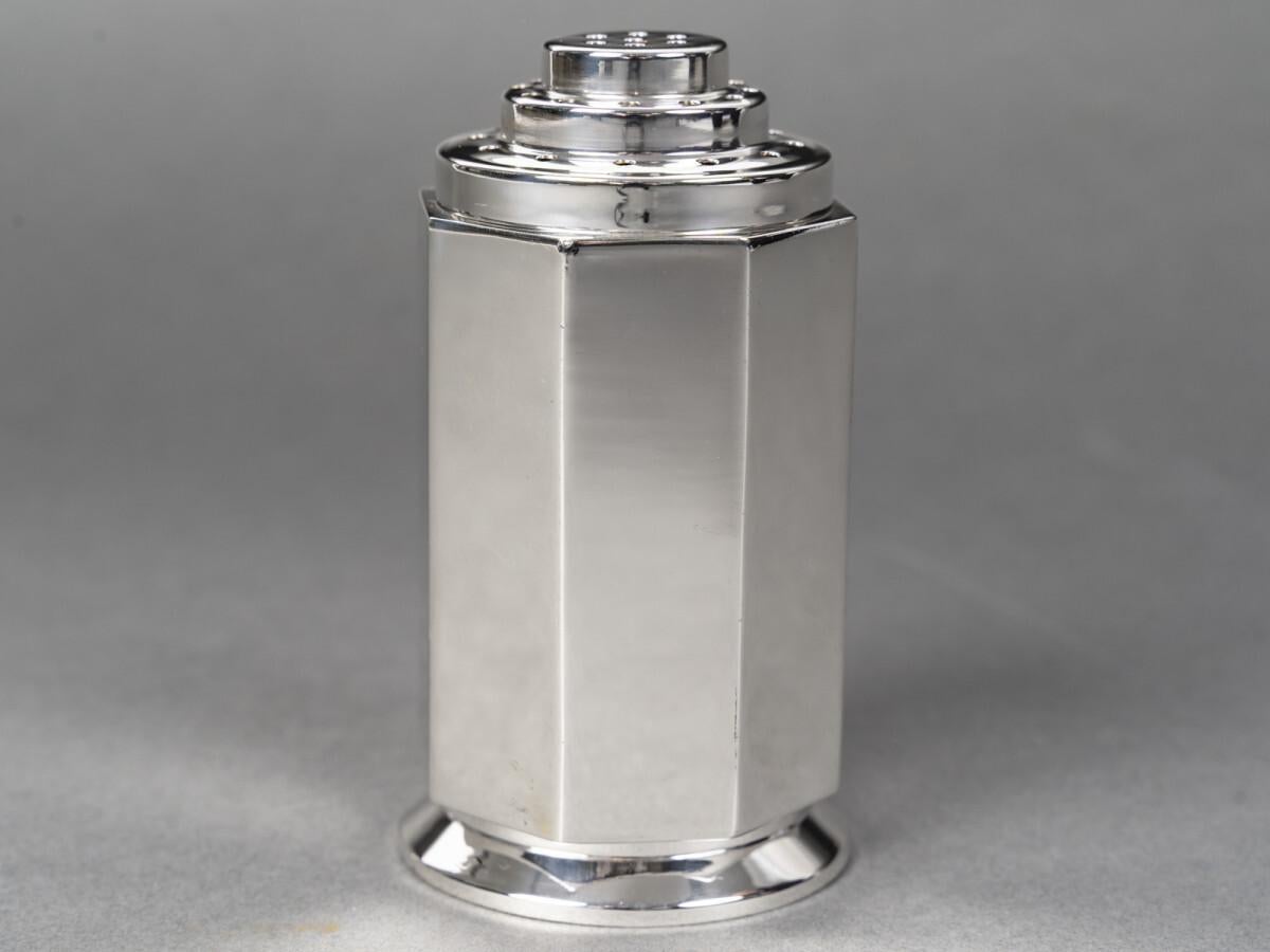 Saupoudroir in argento massiccio di forma ottagonale su una base ogivale sfaccettata, il corpo con otto lati tagliati è liscio, l'interno è in vermeil. Il coperchio avvitato è perforato su tre livelli. Il retro presenta un'incisione di tre donne