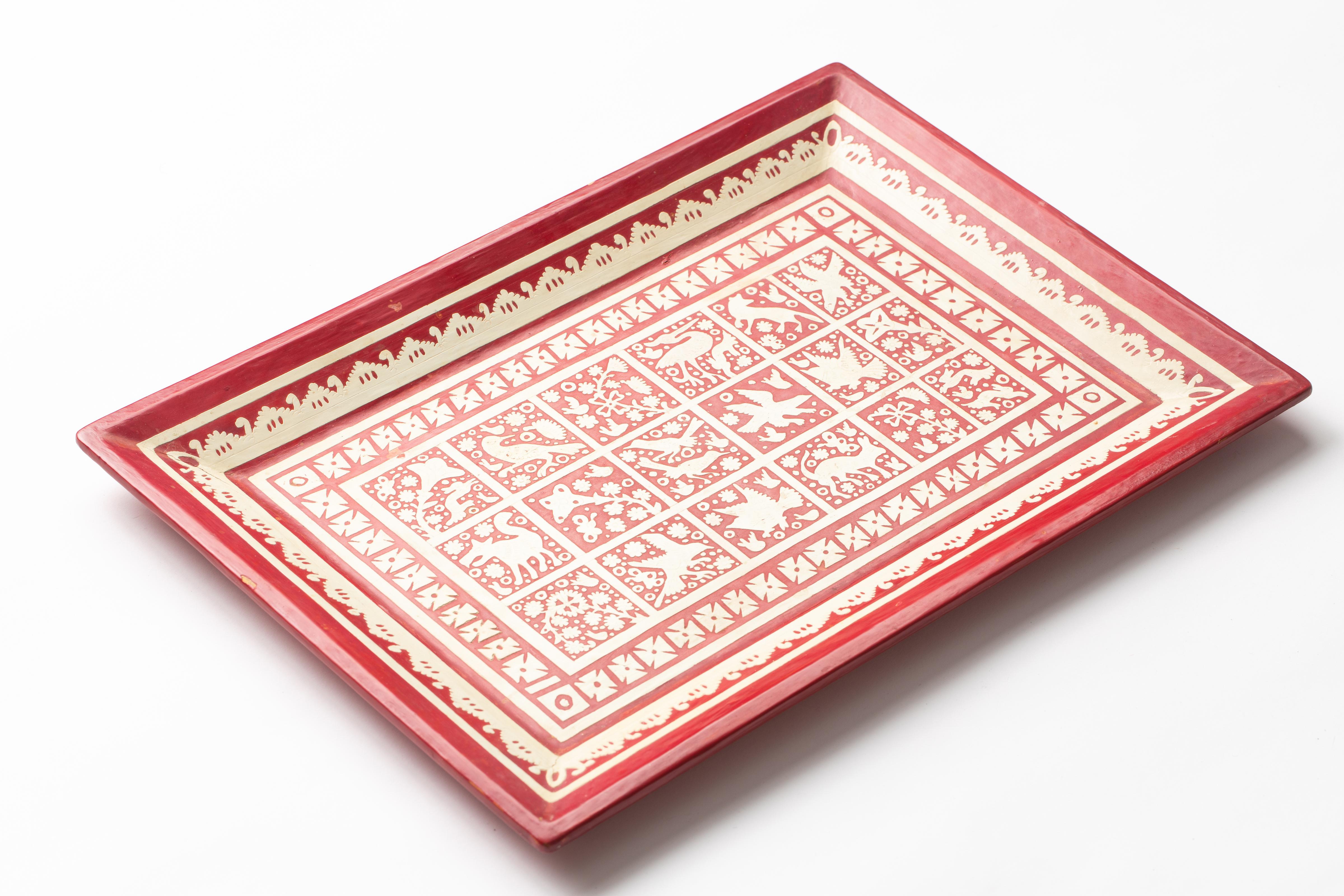 Mexican red lacquered wood serving tray, with hand carved native flora and fauna designs in ivory lacquer. Olinala, Guerrero, Mexico, circa 1960s.
 