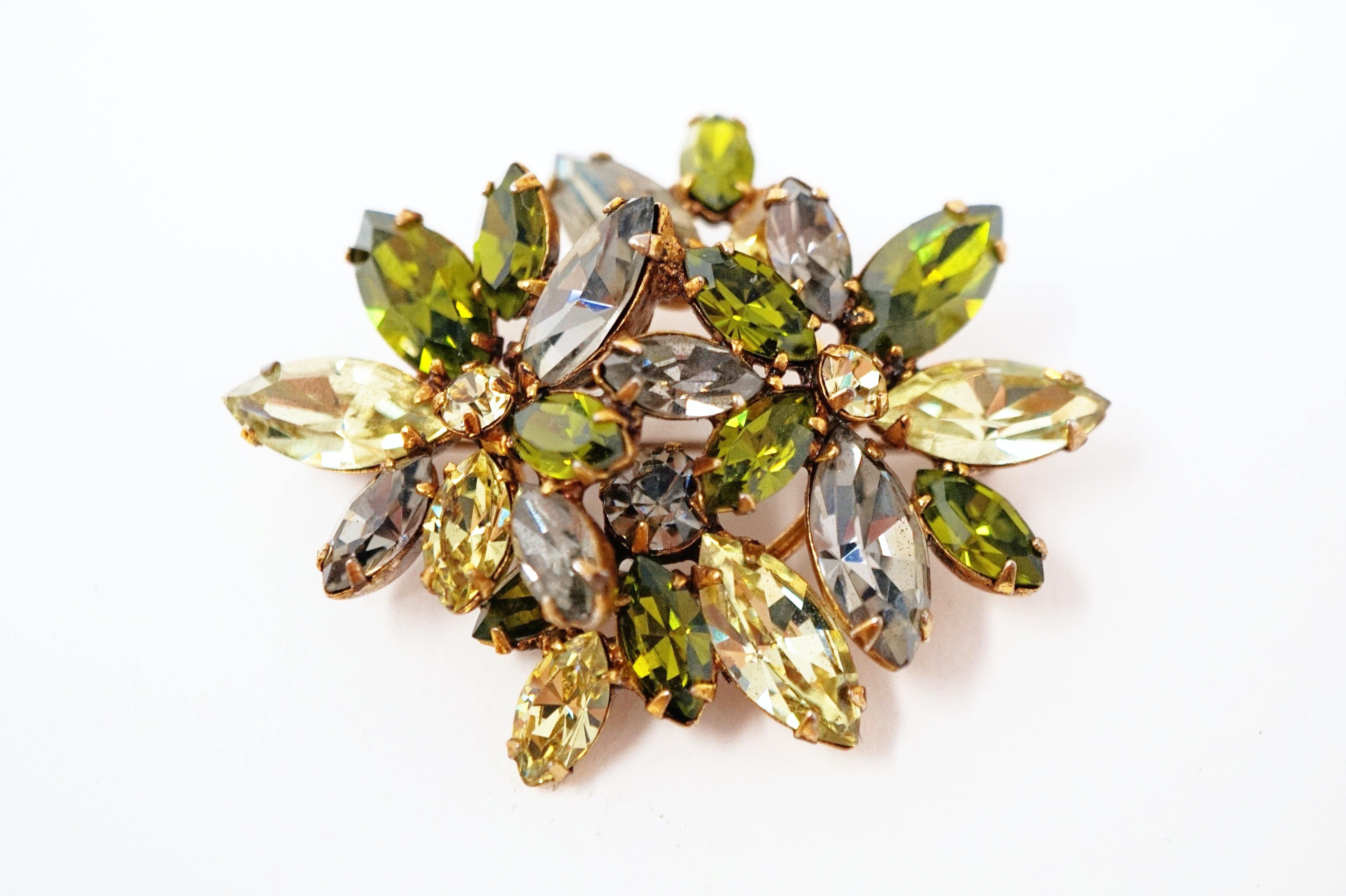 This gorgeous vintage rhinestone brooch by Regency, circa 1950s, is a stunning piece of jewelry history!  Comprised of prong set olive, moss and smoke-colored rhinestones in a floral motif with gold tone hardware.  A wonderful addition to your