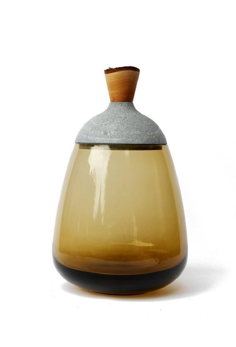Olive and soapstone terra stacking vessel, Pia Wüstenberg
Dimensions: D 23 x H 37
Materials: glass, wood, soapstone
Available in other colors.

Dense in its tones and materials, and in the same time refined in its composition, Terra is an ode