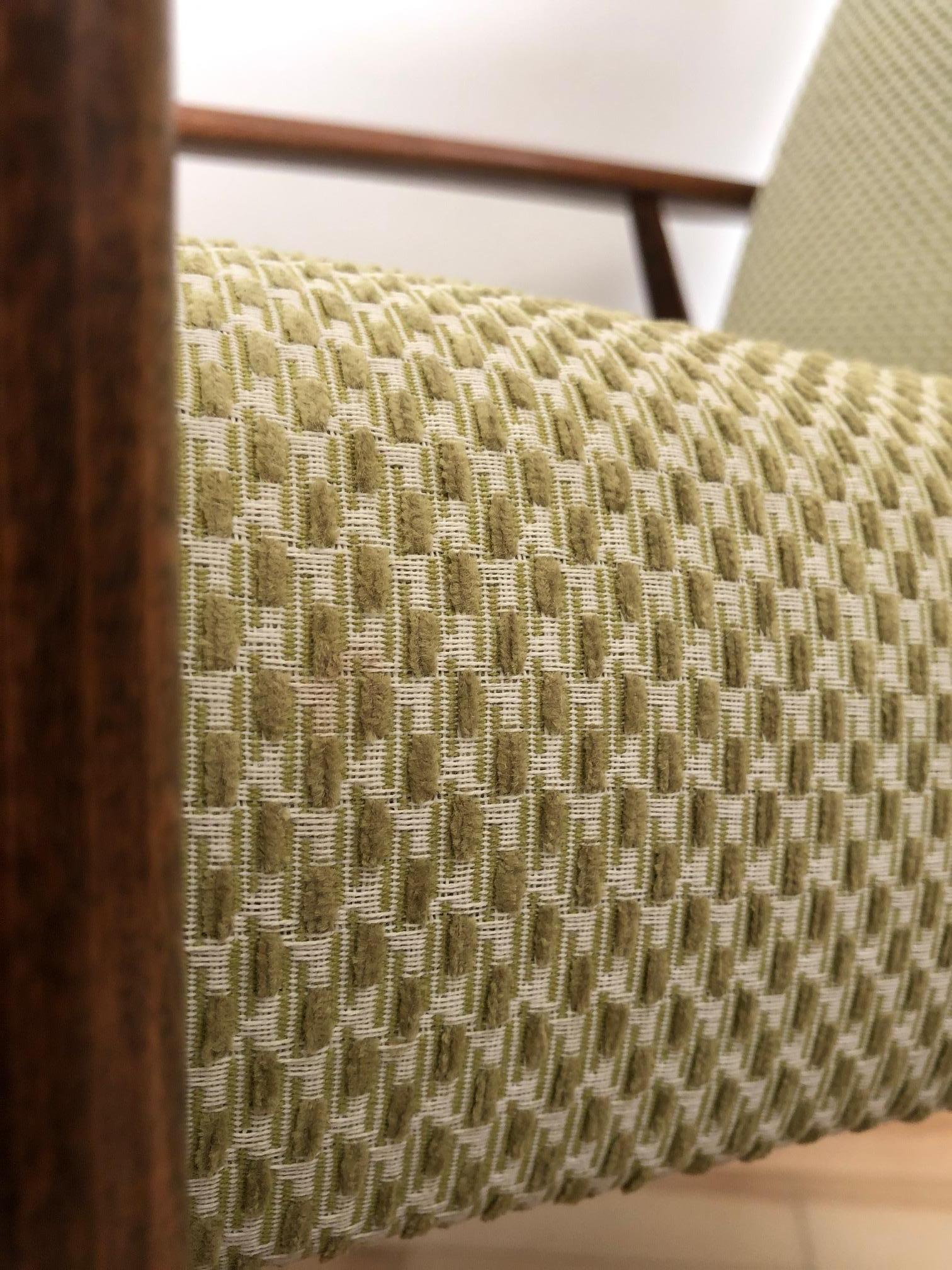 Le fauteuil conçu par Henryk Lis. La structure est en bois de hêtre recouvert d'un vernis satiné semi-mat. La tapisserie d'ameublement est un tissu italien lourd de couleur olive. L'ensemble a été entièrement restauré - à la fois le bois et la