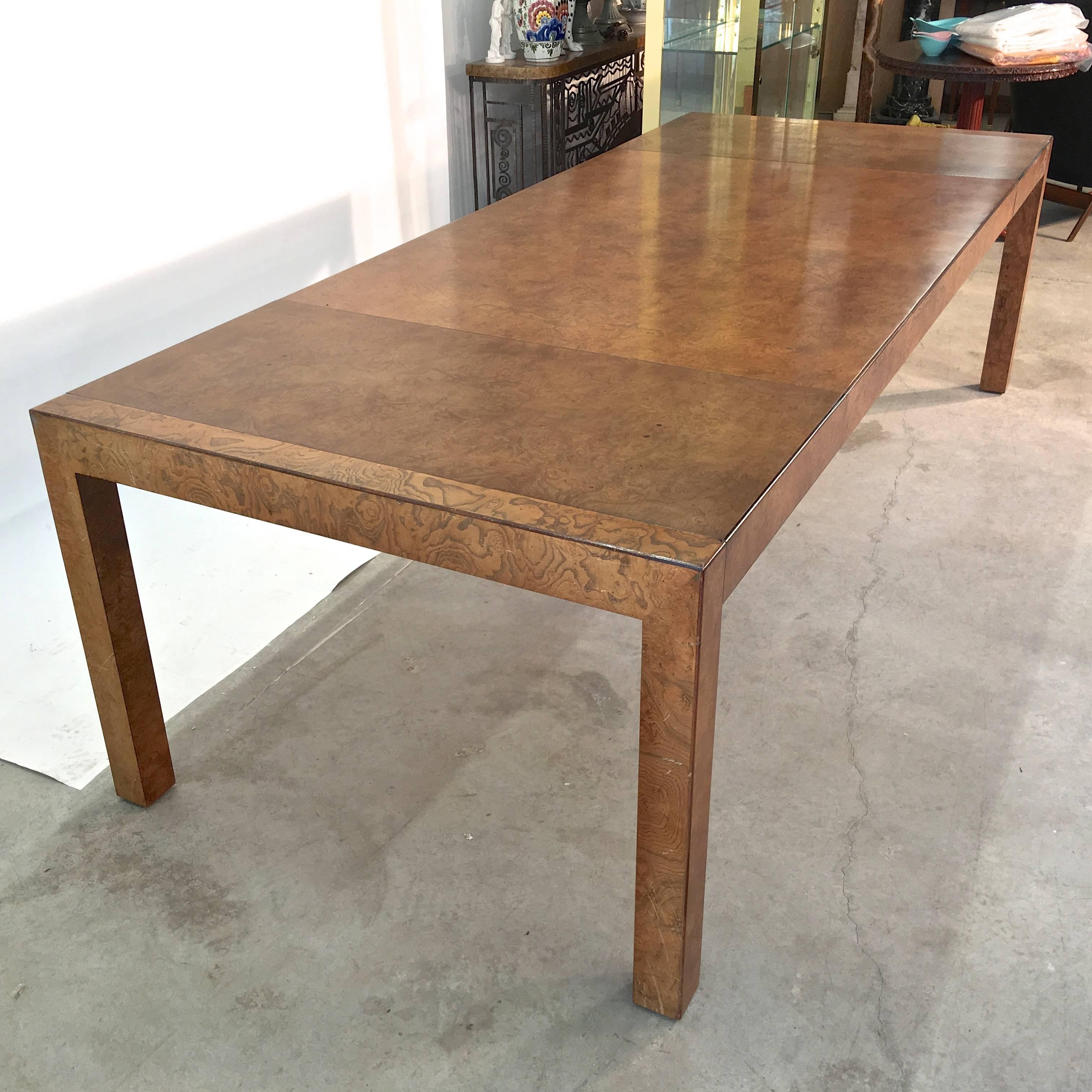 Classic parsons form extendable dining table produced in 1973 by John Widdicomb Co. Makers of Fine Furniture, Grand Rapids, MI in olive ash burl with walnut trim. Single previous owner. Very good condition. Comes with two 20