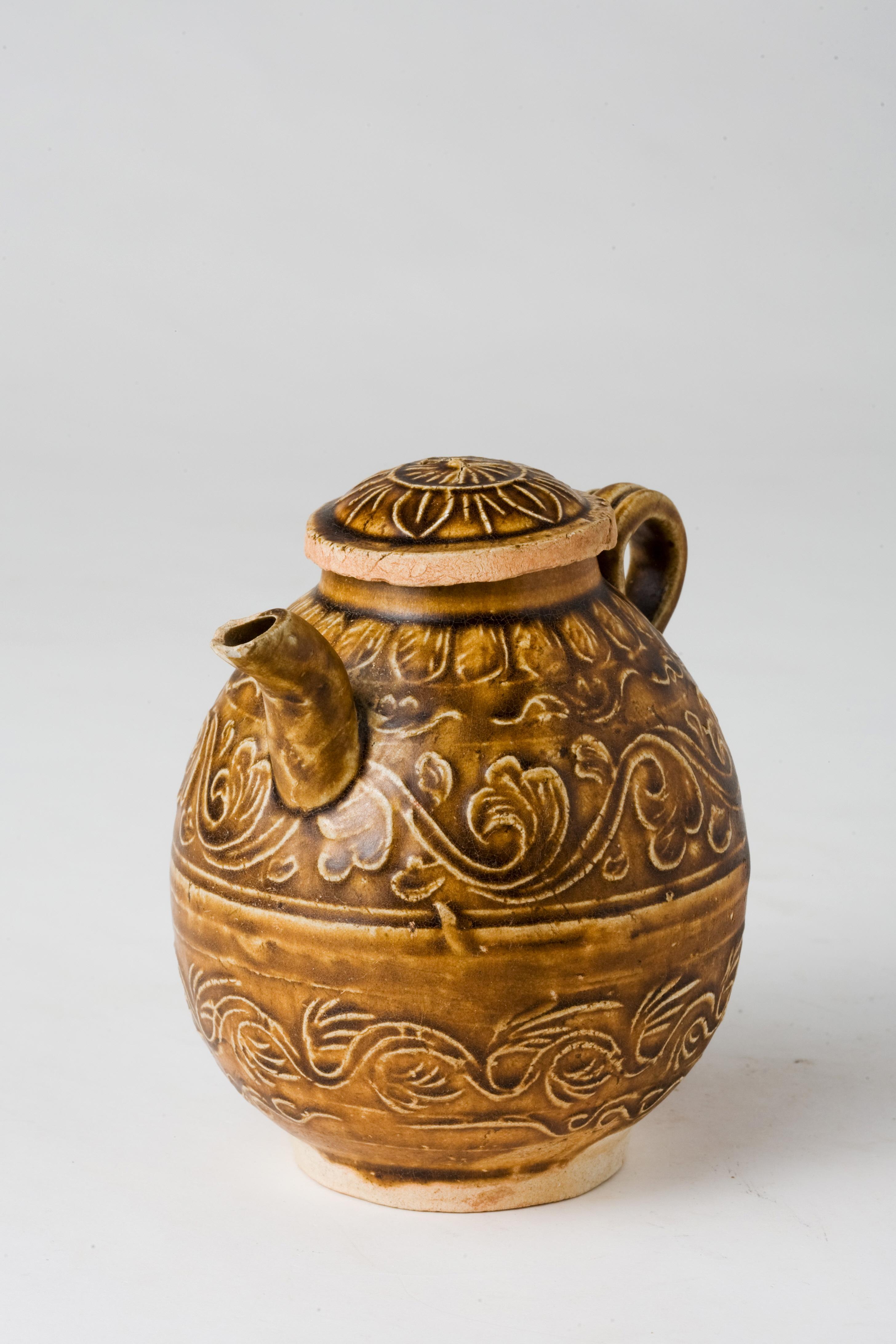 The oviform body molded with floral and leaf pattern reminiscent of waves, all covered with an olive-brown glaze. The glaze drips and irregular streaks of brown-glazed pottery from that period are distinctive aesthetic elements of Song-Yuan Dynasty
