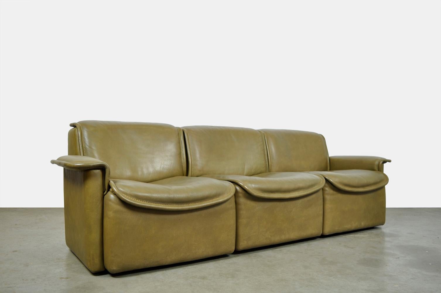Original and rare 3-seater buffalo leather sofa DS-12 produced by De Sede Switzerland, 1970s. The 3-person vintage sofa consists of three separate elements and is covered with thick olive green saddle-stitched leather. Original sofa in a special