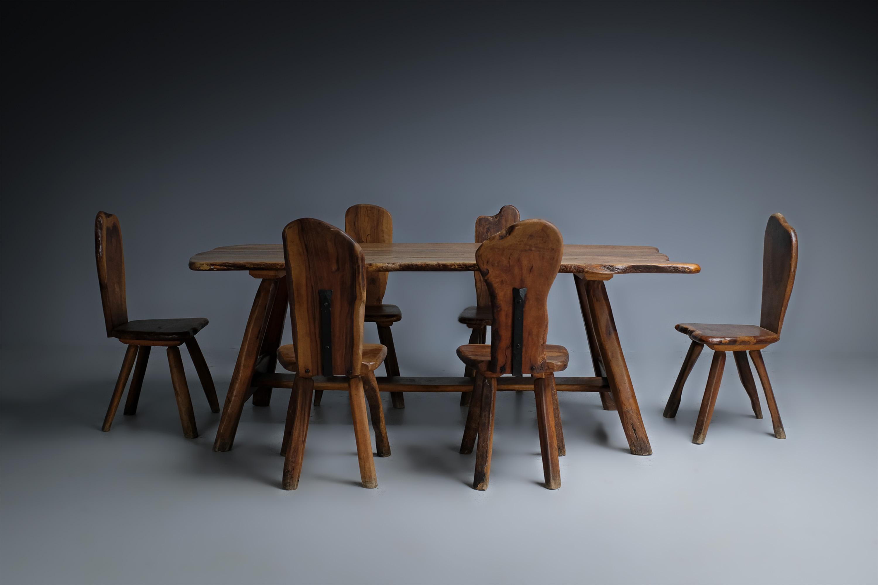 This dining room, made in the 1960s, is a true representative of France's rustic brutalist movement of the post-war period.

It is a set of six chairs made of olive wood that gathers around a table made of the same material. The wood is