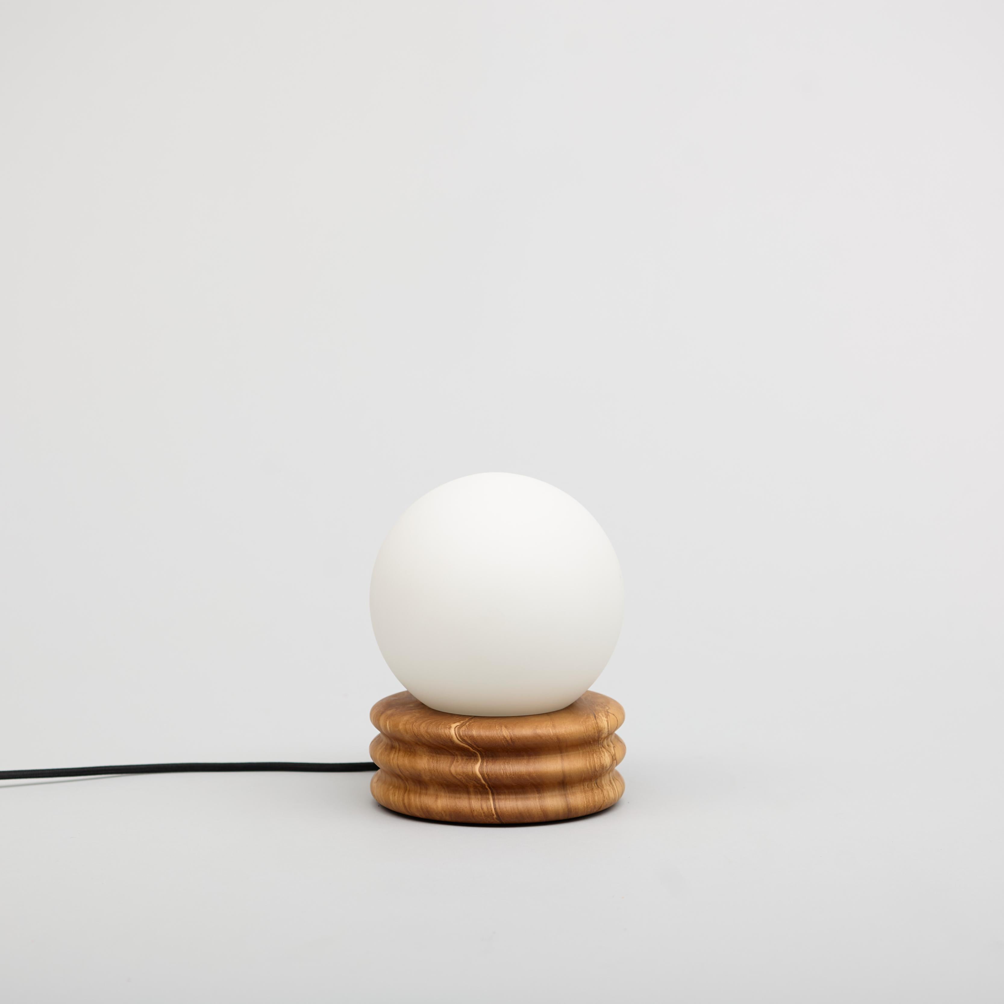 A glass globe cradled in walnut ripples; a full moon resting on still water. Beautiful in the daylight, it comes to life at night.

One 6
