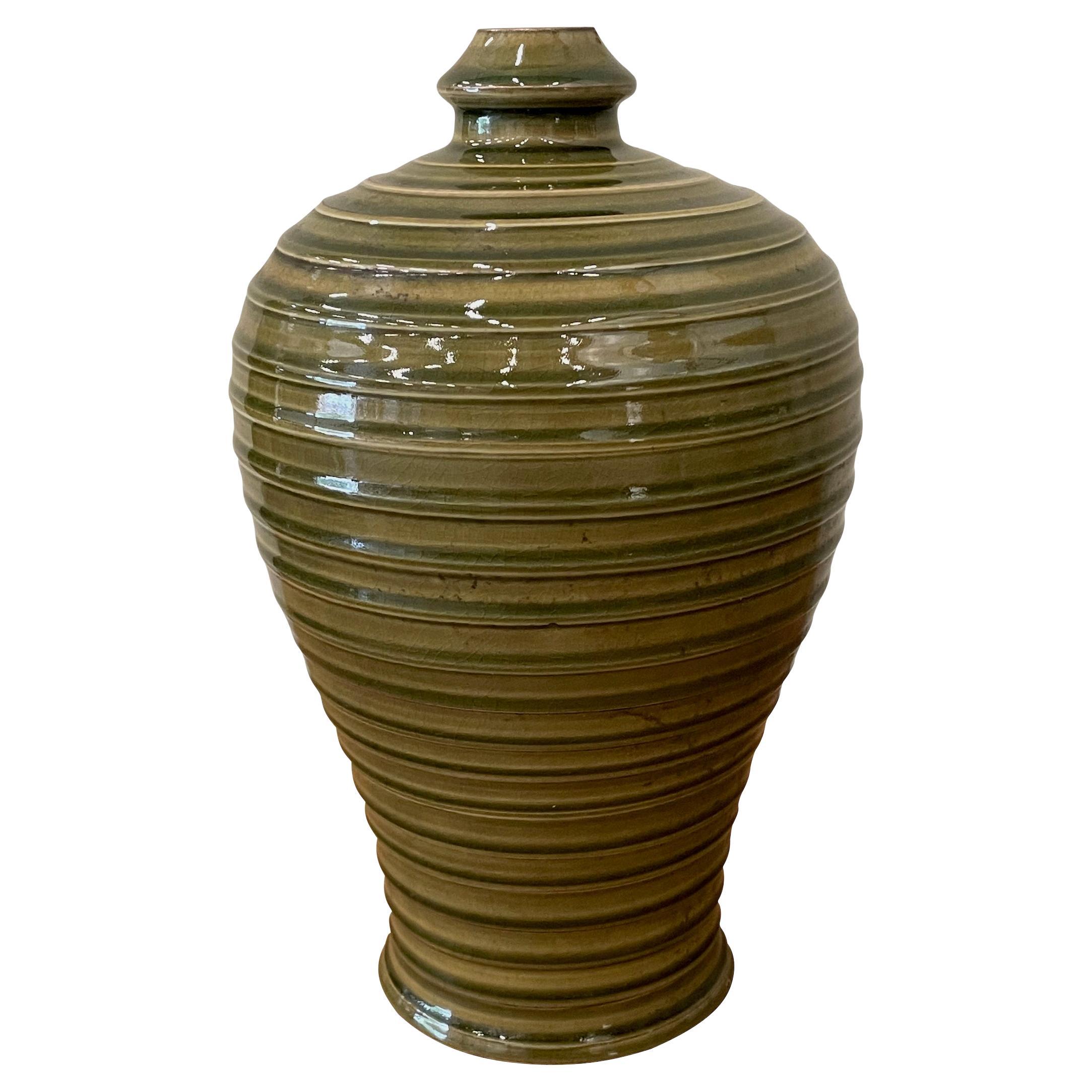 Contemporary Chinese glossy olive glazed vase.
Thin spout opening.
Overall horizontal rib detailing.
Two available and sold individually.
Part of a large collection.