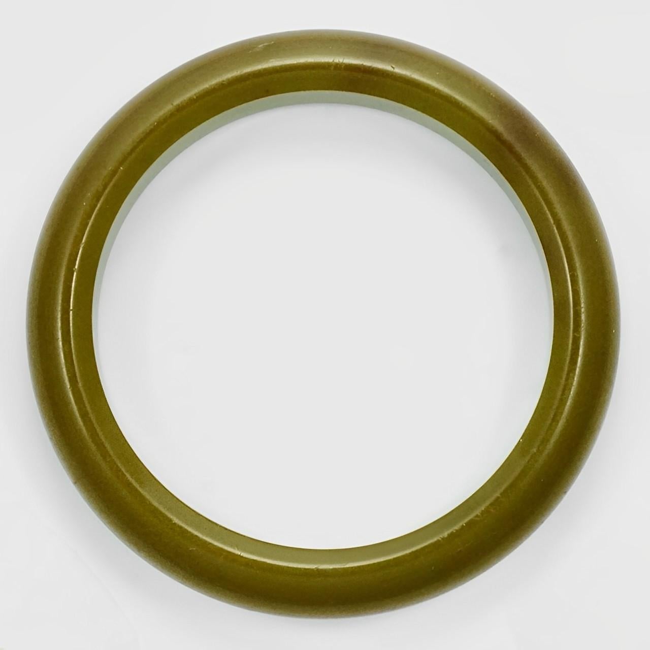 Lovely olive green Bakelite bangle bracelet. Inside diameter 6.5 cm / 2.5 inches by width 9 mm / .35 inch. The bangle has some scratching.

This is a wonderful classic Bakelite bangle, circa 1930s.