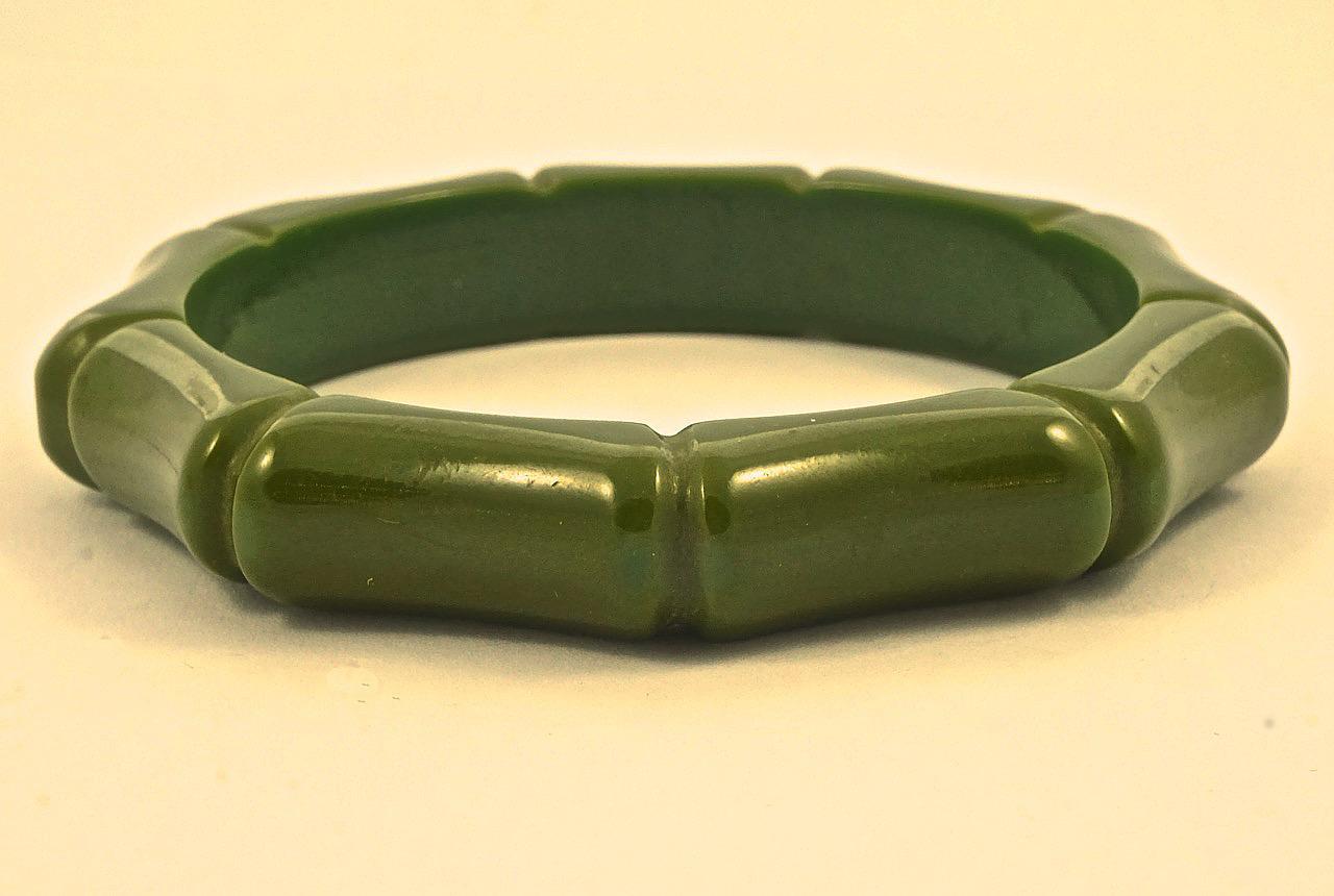 Wonderful olive green carved Bakelite bangle with a bamboo design. Inside diameter 6.5cm / 2.5 inches by width 1.2cm / .47 inch. The bangle is in very good condition.

This is a beautiful vintage carved Bakelite bangle in a lovely olive green. 