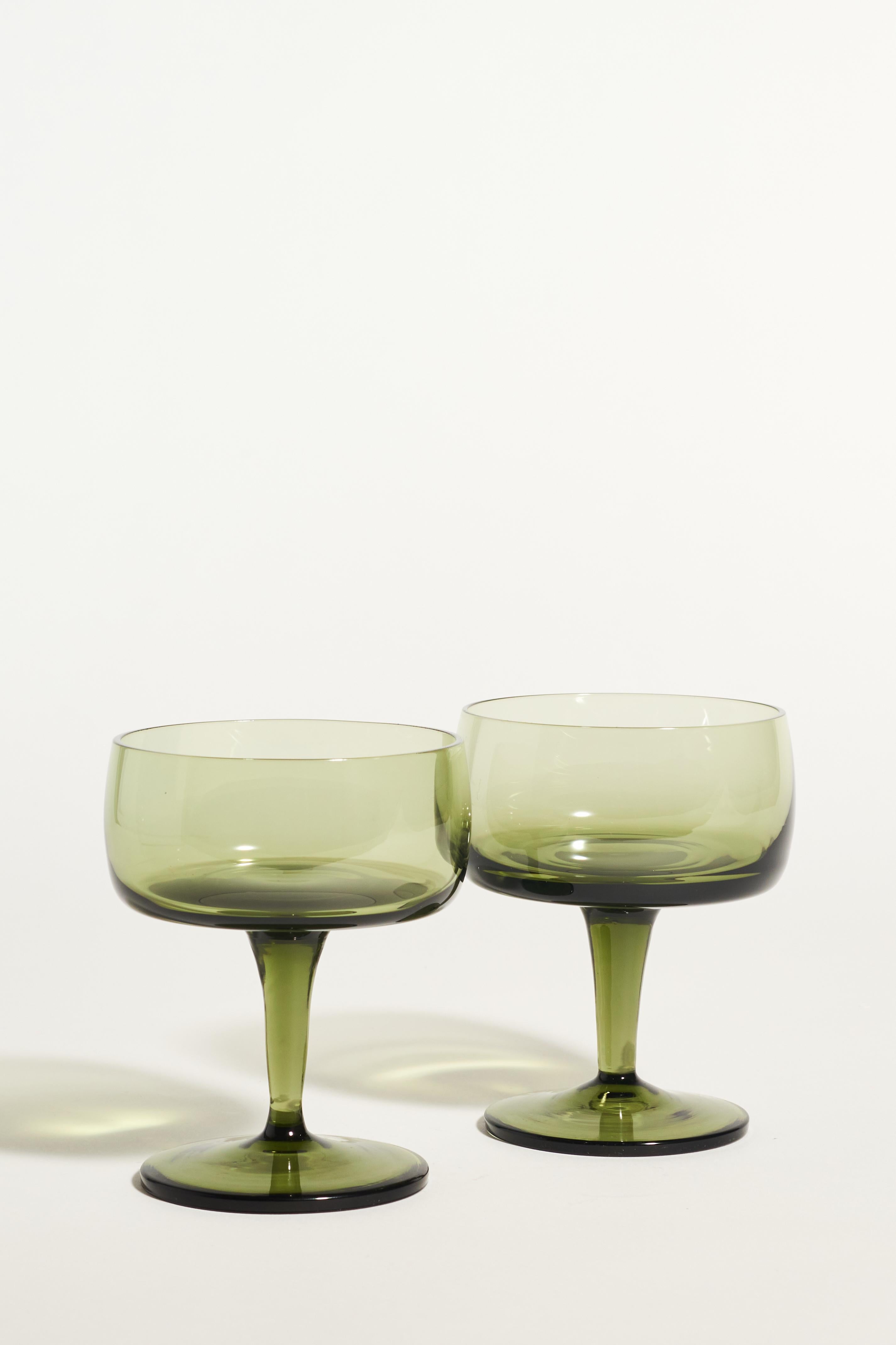 Olive green cocktail glasses with tapered stems.
