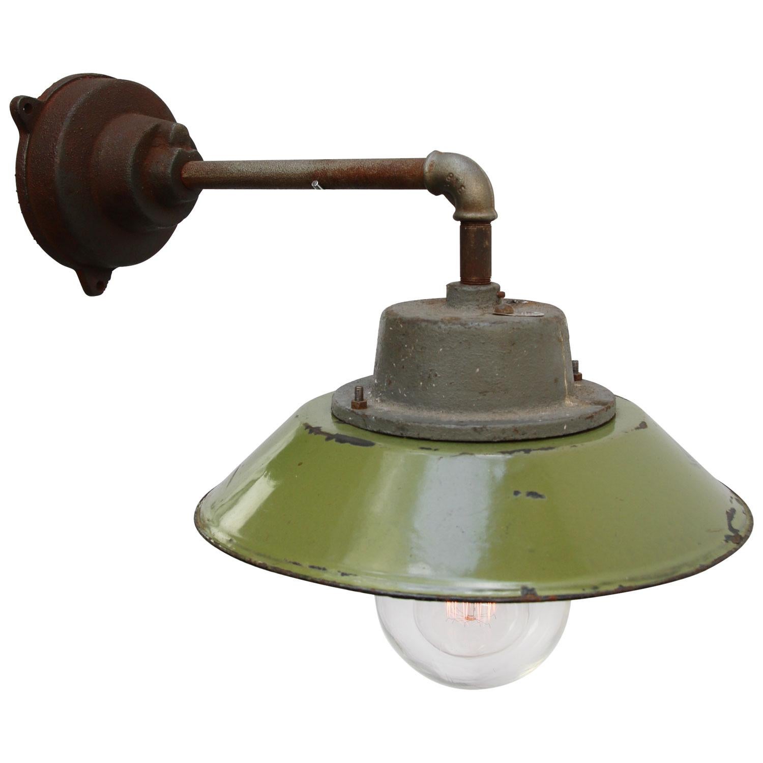 Green colored enamel industrial wall light with white interior.
Clear glass.

Diameter cast iron wall mount: 12 cm, 3 holes to secure.

Weight: 5.5 kg / 12.1 lb

For use outdoors as well as indoors. 

Priced per individual item. All lamps