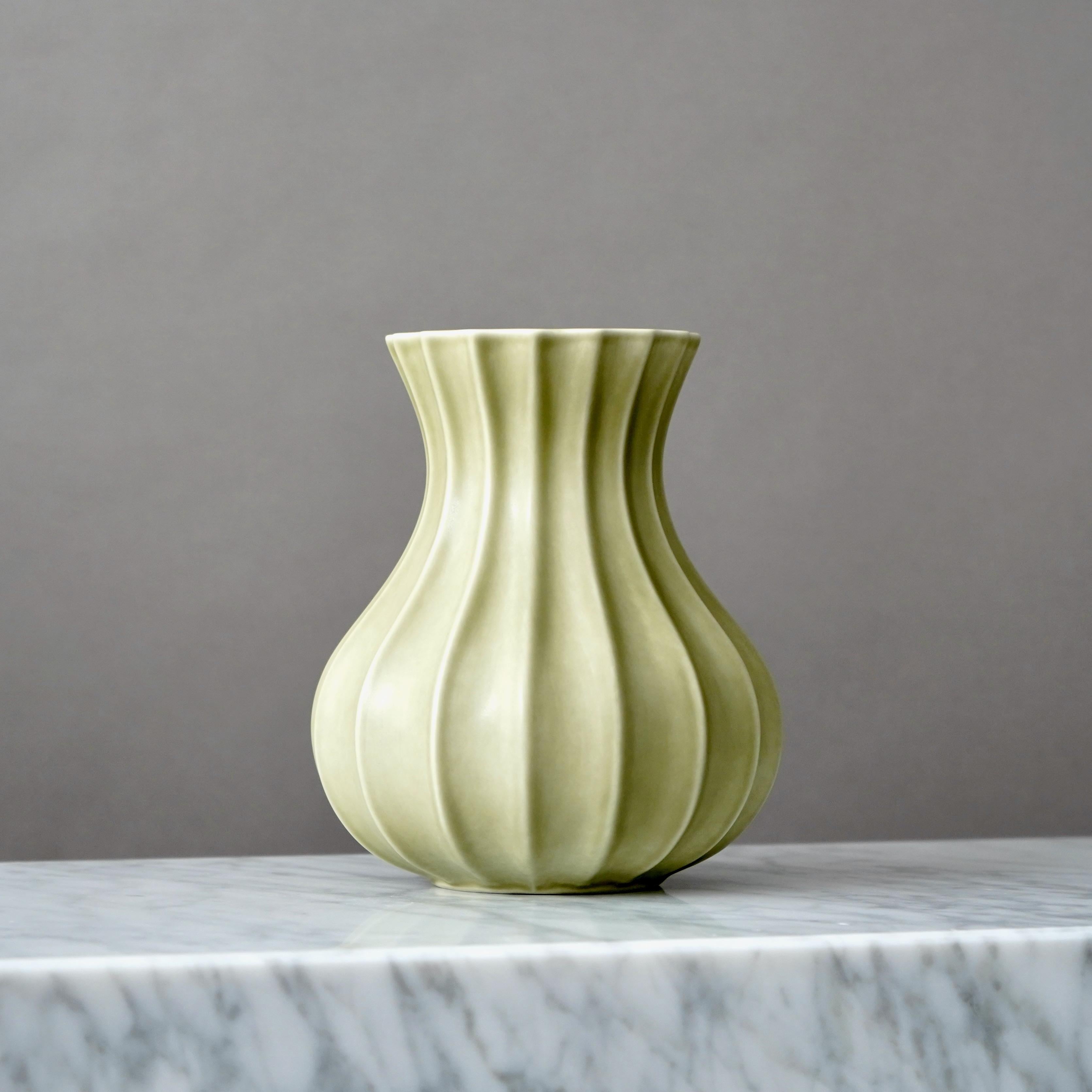 A beautiful fluted olive green stoneware vase.
Designed by Pia Ronndahl in 1980s for Rorstrand, Sweden.

Excellent condition. Factory first.
Stamped with signature and makers mark.


