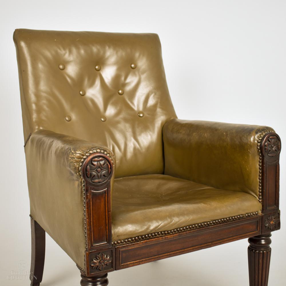Olive green leather Georgian Library chair circa 1820. On fine Regency mahogany reeded front legs on original castors. With fine Regency flower carvings to the supporting arms. In good condition with character and a comfortable seat.