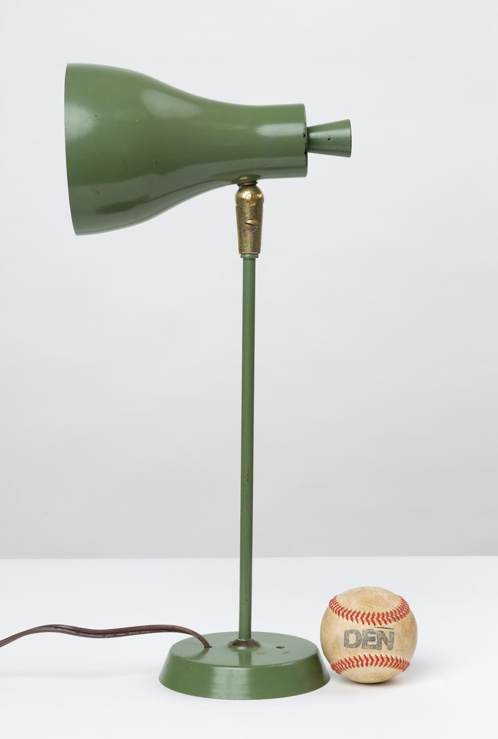 A small, wall-mounted lamp designed by Gerald Thurston for Lightolier. The piece has a tulip shade, an oversized on/off switch, and a plate mount in matching red-enameled metal. A brass joint allows the shade to rotate and extend.

Condition: