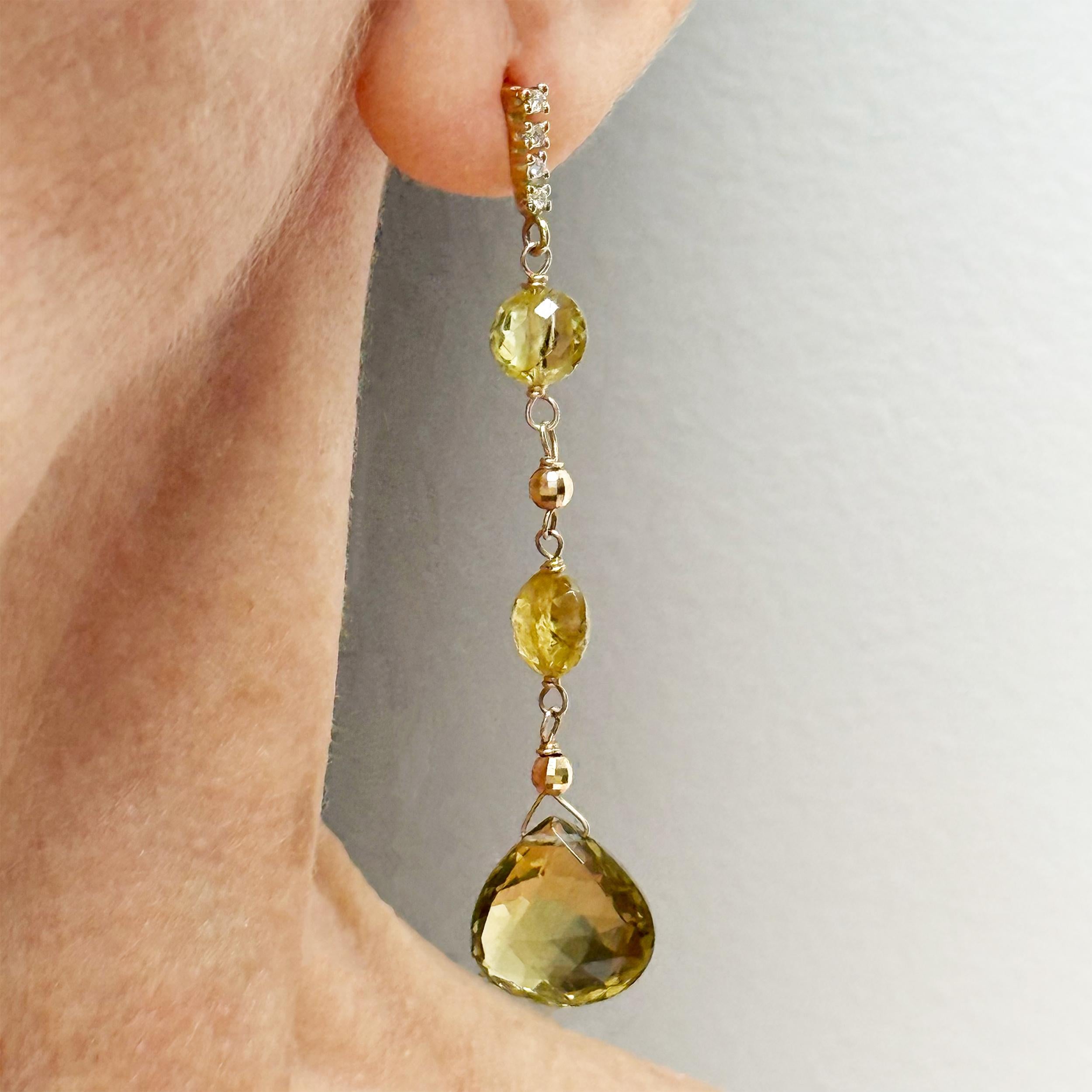 Beschreibung
Elegante Olivenquarz-Tropfen sind mit seltenen grobkörnigen grünen Granaten gepaart und zart mit facettierten 14-karätigen Gelbgoldperlen akzentuiert. Diese Ohrringe hängen an schlanken, linearen Vier-Diamanten-Stiften und bieten ein