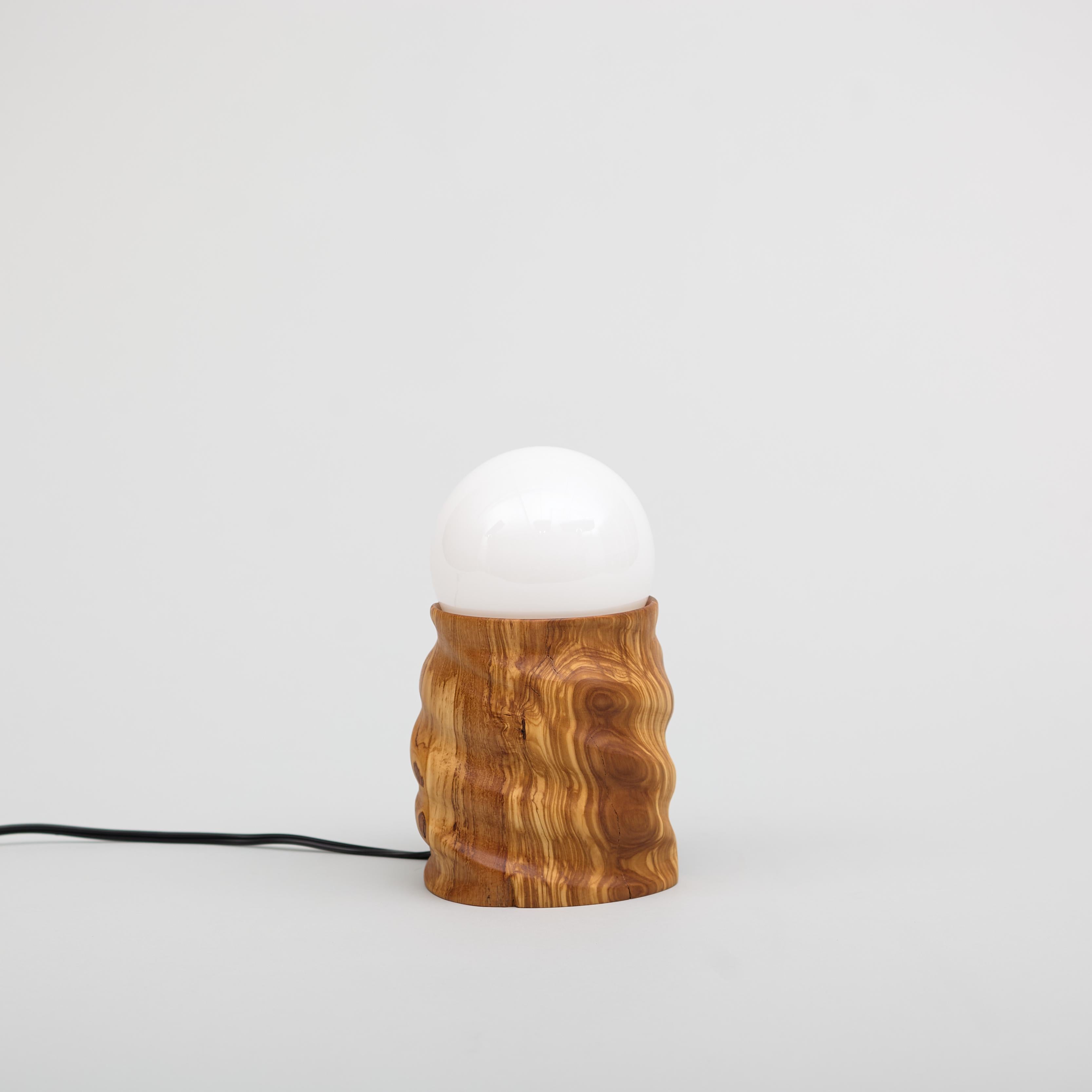 Olive wood lamp hand-carved on the lathe using a time-intensive technique called multi-axis turning. Comes with an LED light bulb and in-line dimmer switch. The olive wood is sourced from a fallen tree off Canyon Crest Road in Altadena,