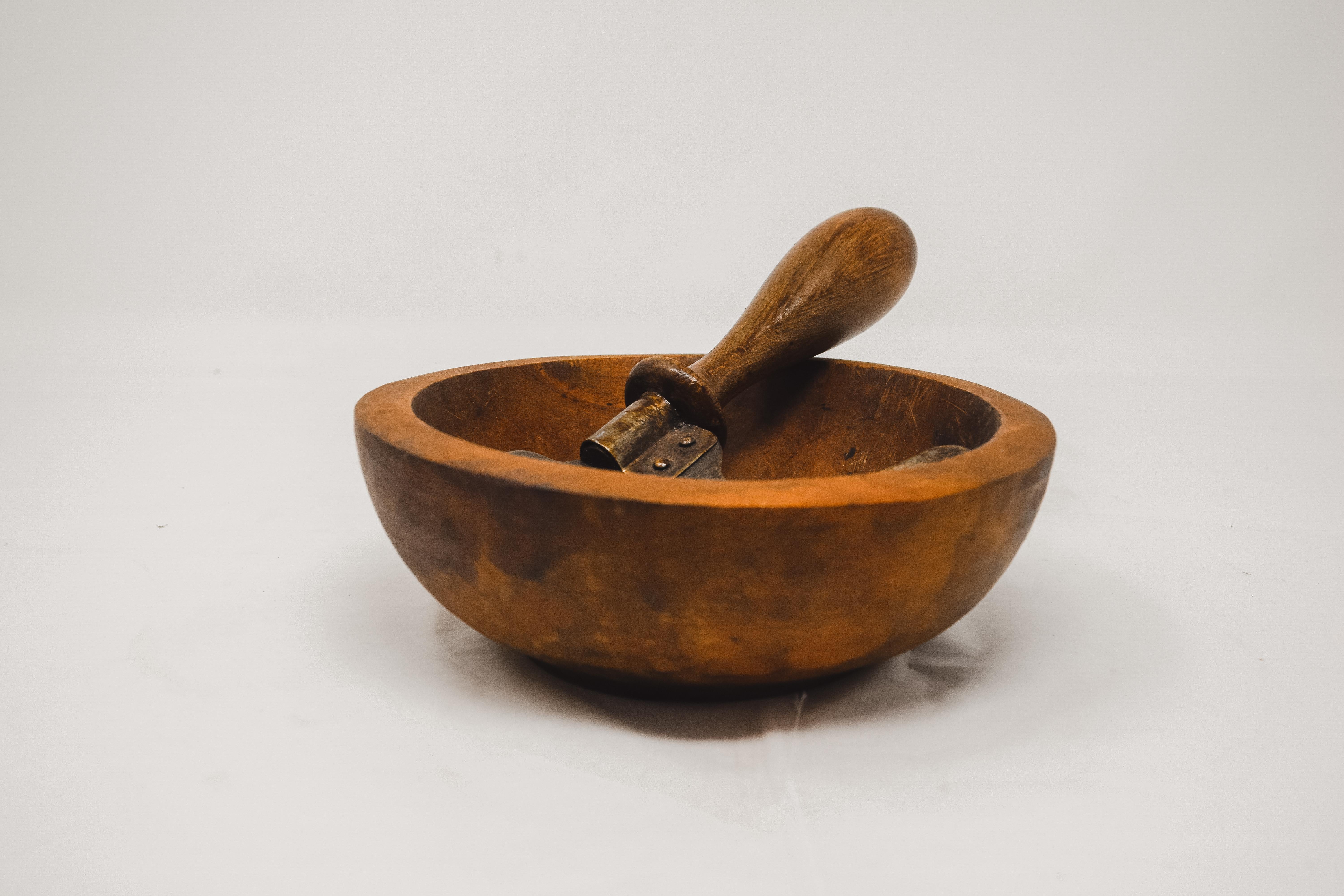 Herb cutter and olive wood bowl from France. The chopper each has an upright wooden handle attached to a crescent shaped steel blade with a wraparound riveted metal strip. The lathe turned bowls have no splits or cracks. The blade has an aged patina
