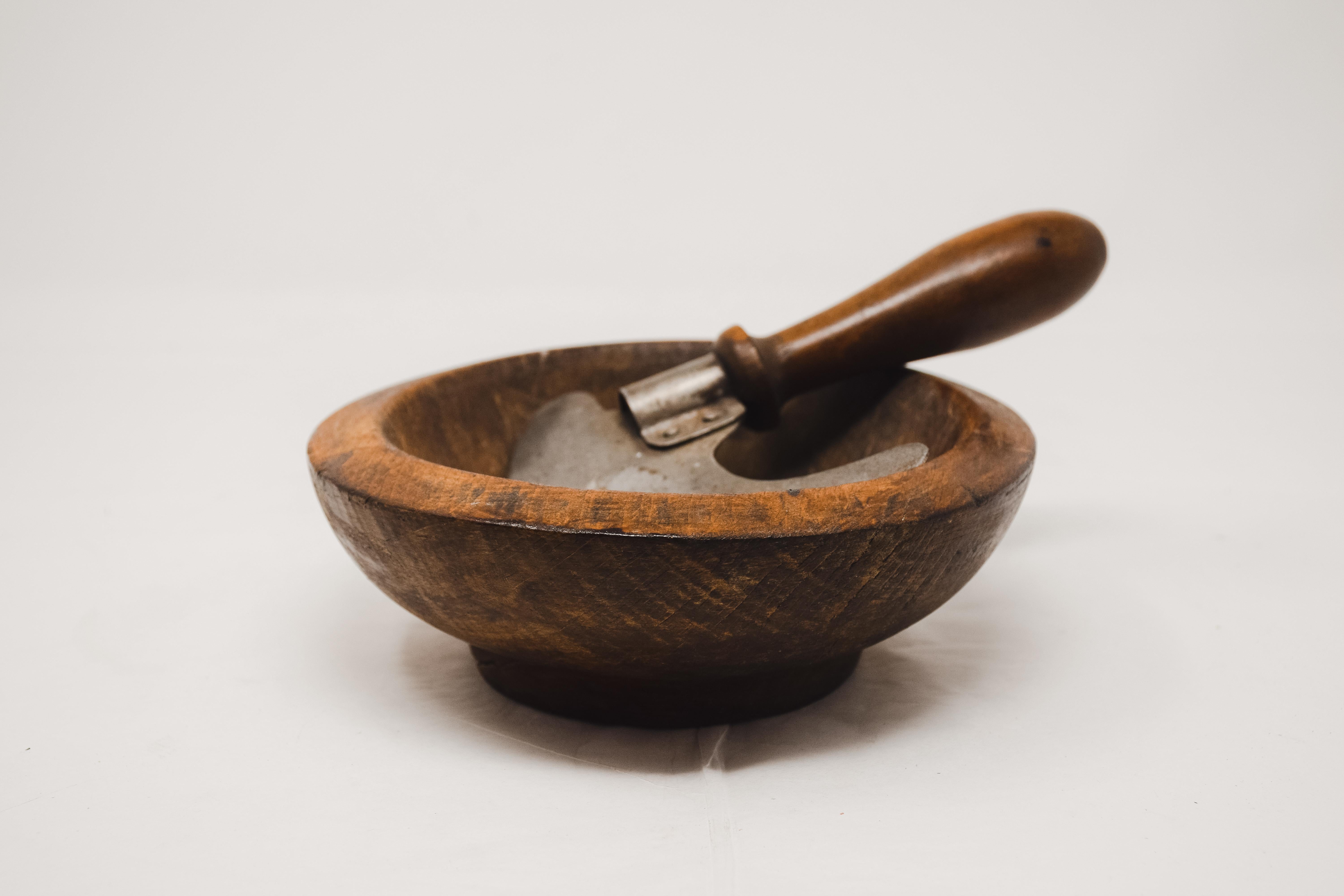 Herb cutter and olive wood bowl from France. The chopper each has an upright wooden handle attached to a crescent shaped steel blade with a wraparound riveted metal strip. The lathe turned bowls have no splits or cracks. The blade has an aged patina