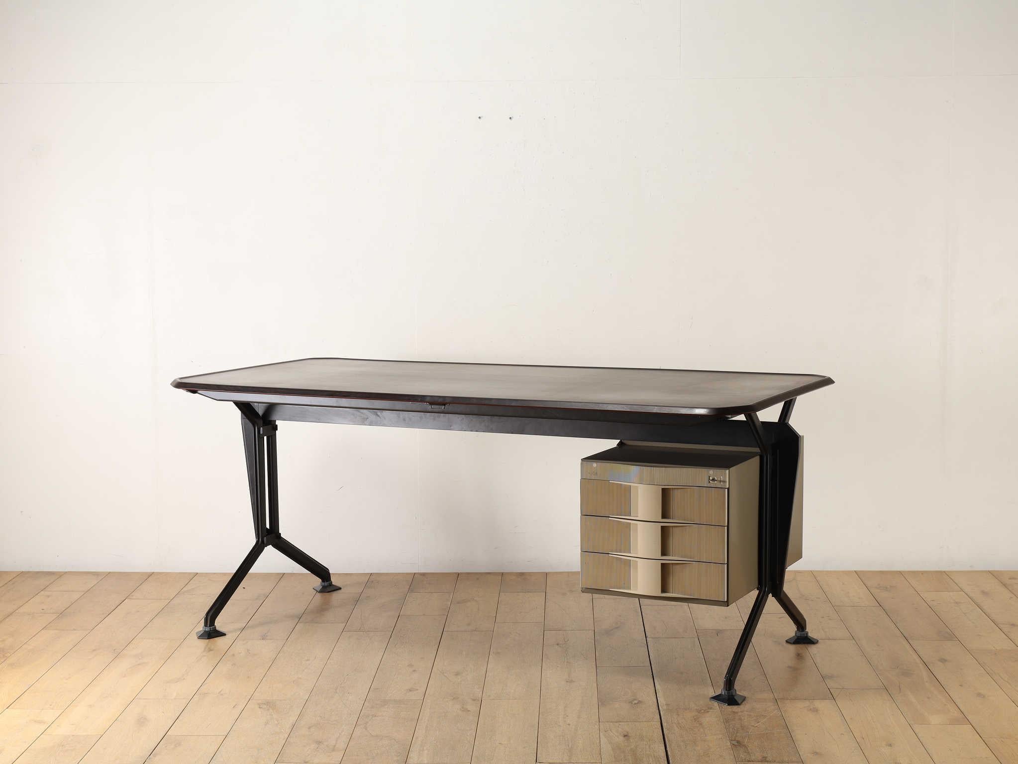 Una scrivania di Olivetti, l'azienda italiana famosa per le sue macchine da scrivere. Il piano di lavoro spazioso e i cassetti offrono ampio spazio per documenti e file, rendendola un'ottima scelta come scrivania da lavoro. Il piano di lavoro in