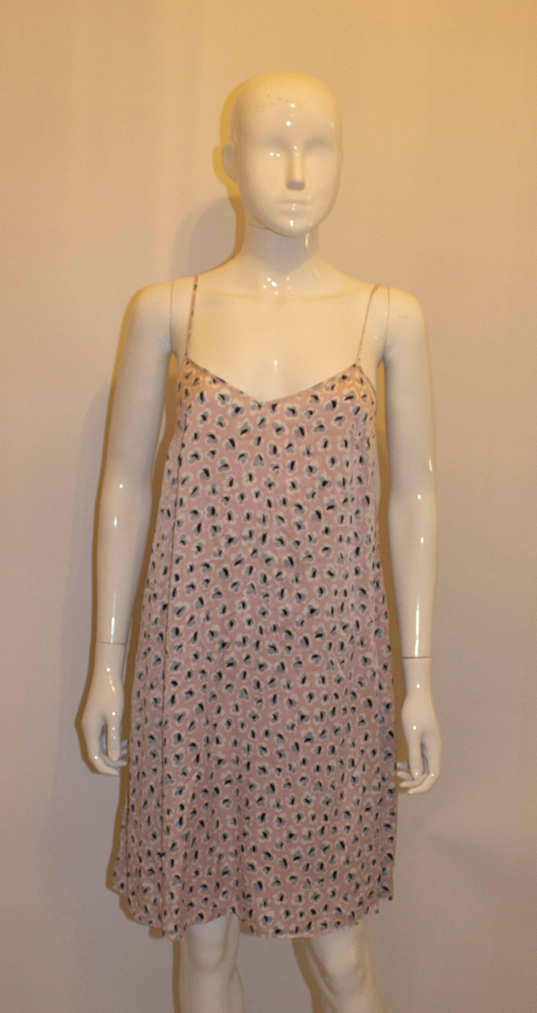 A pretty silk slip dress by Olivia von Halle. The dress has a pink background with a black and white print. It has adjustable straps and a pocket on either side. 
Size 3 Bust up to 38'', length 33''