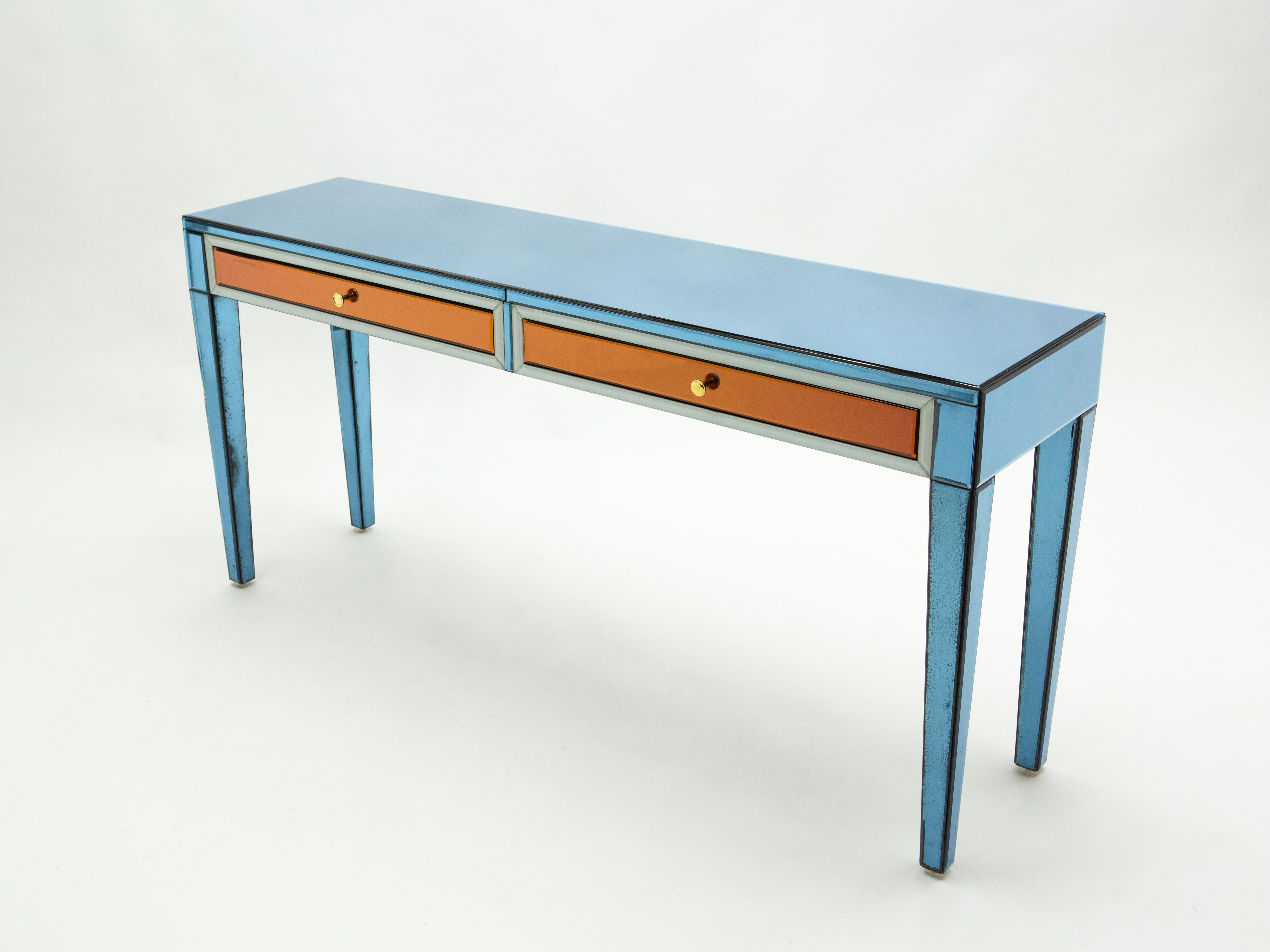 Beautiful “bleu blanc rouge” color mirrored console table designed by Olivier de Schrijver for ODE DESIGN in the 1990s. It features sleek expanses of mirrors all around, with two large drawers. Part of a limited edition of 5, this is the number 3 of