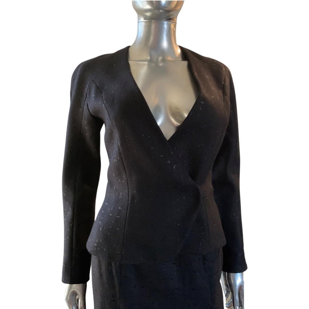A very sexy and fitted suit by Oliver Theyskens. A fitted architectural shape jacket with optimal use belt and sexy fitted pencil skirt with front slit. The fabric is unique. Not plain wool, it has a modern black metallic thread in abstract pattern.