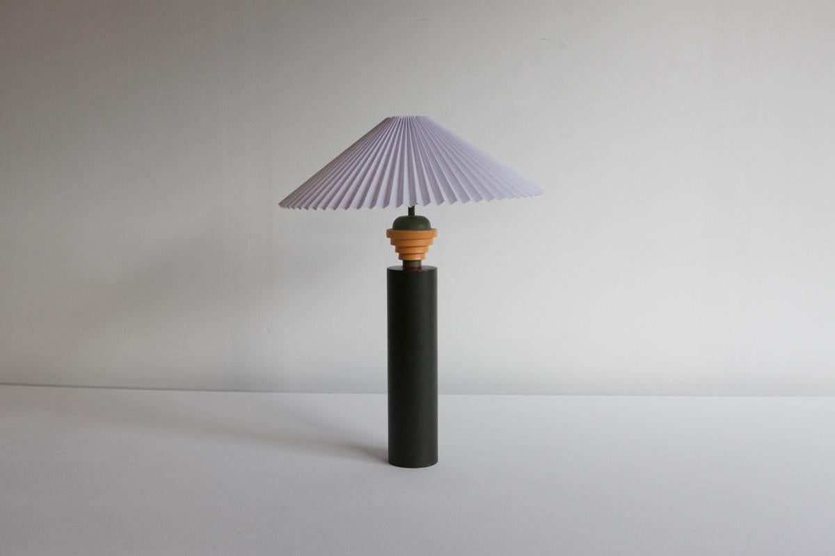 Post-modern table lamp by Olivier Villatte. Green cylindrtcal base with stepped details and a pleated shade.
