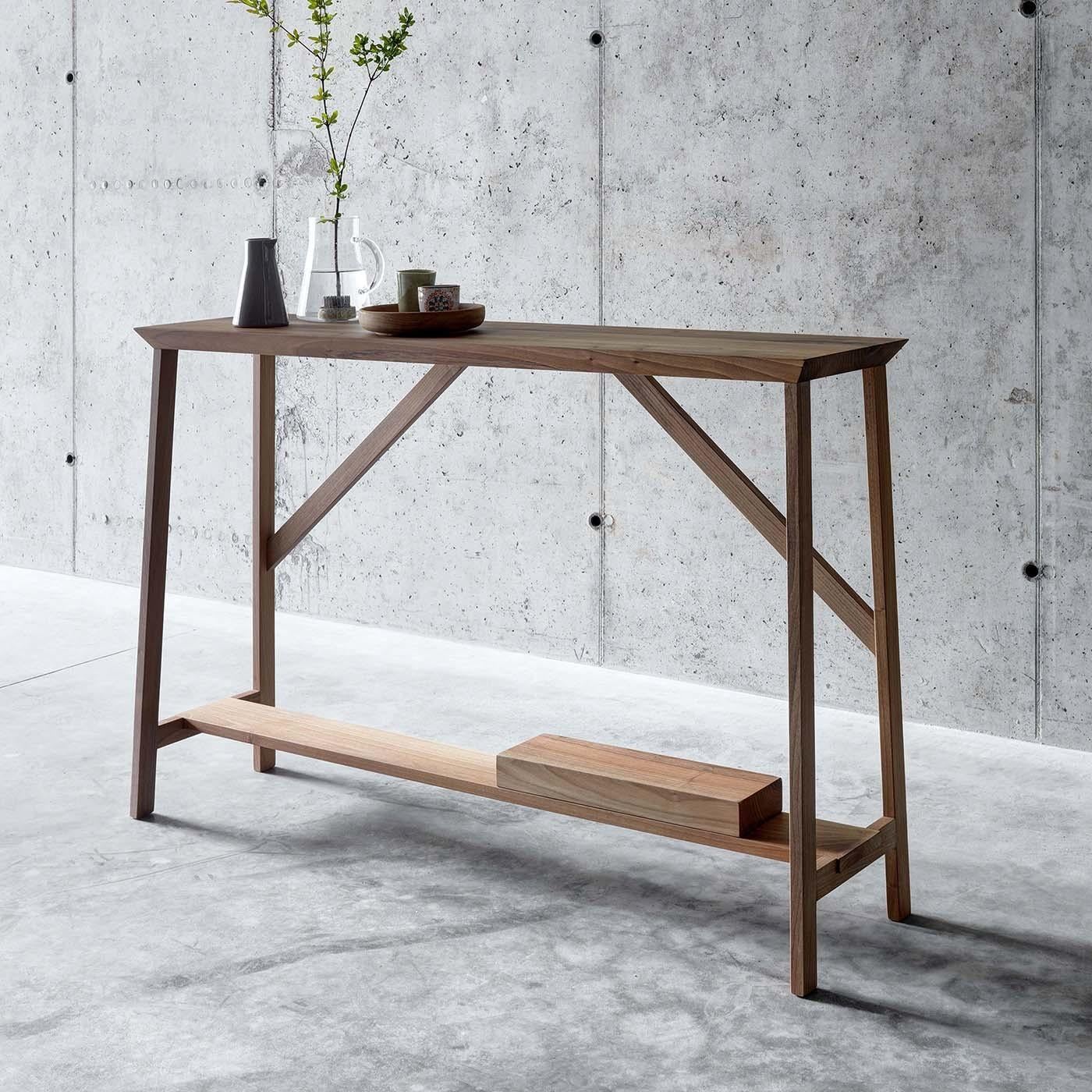 This elegant console is an exercise in balance and lightness. Its linear silhouette was designed by Act_Romegialli and crafted entirely of solid walnut. Its delicate elements, crossing at 90 and 45-degree angles, make up a modern interpretation of