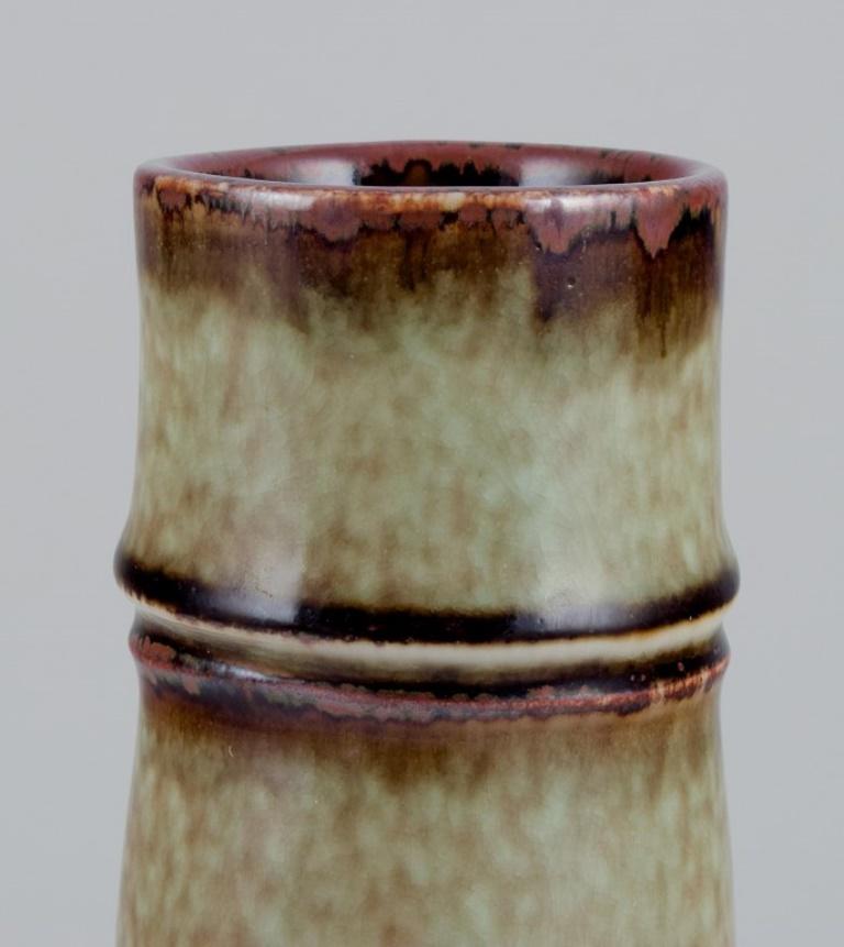 Olle Alberius (1926-1993) für Rörstrand, Schweden. 
Große Keramikvase in Braun- und Grüntönen.
Ungefähr in den 1970er Jahren.
Markiert.
In perfektem Zustand mit natürlichen Glasurrissen.
Erste Fabrikqualität.
Abmessungen: Höhe 28,4 cm x Durchmesser