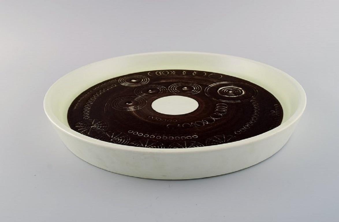 Olle Alberius für Rörstrand. 
Große Sarek-Schale aus handbemalter und glasierter Keramik mit geometrischen Mustern. Schwedisches Design, 1960er/70er Jahre.
Maße: 36 x 5 cm.
In ausgezeichnetem Zustand.
Gestempelt.
1. Fabrikqualität.