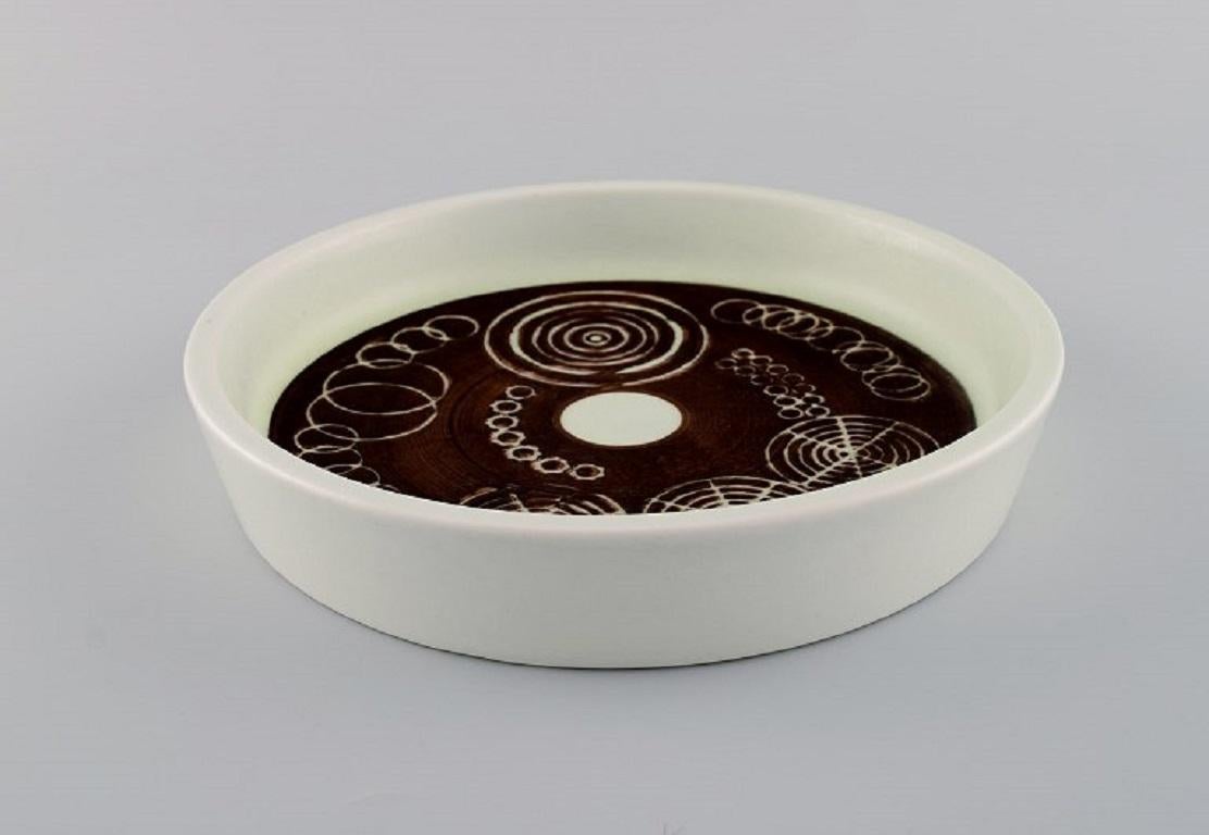 Olle Alberius pour Rörstrand. 
Plat / bol Sarek en céramique peinte et émaillée à la main avec des motifs géométriques. Design suédois, années 1960/70.
Mesures : 21 x 4 cm.
En parfait état.
Estampillé.
1ère qualité d'usine.