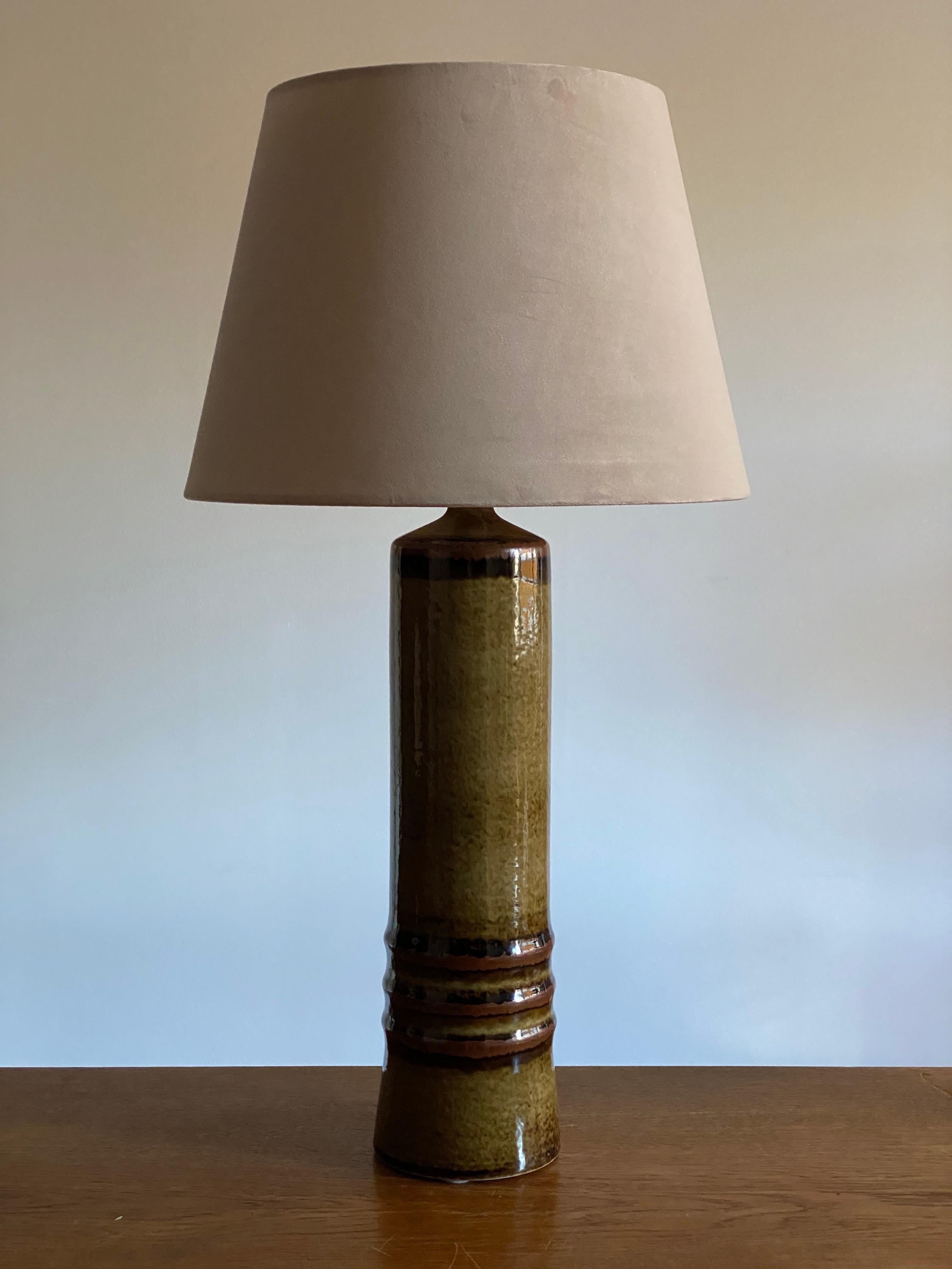 A large and sculptural table lamp, designed by Olle Alberius and produced by Rörstrand. Marked. Features a sculptural form and a highly artistic green / black / brown glaze. 

Lampshade attached is for illustration. Sold without lampshade. Stated