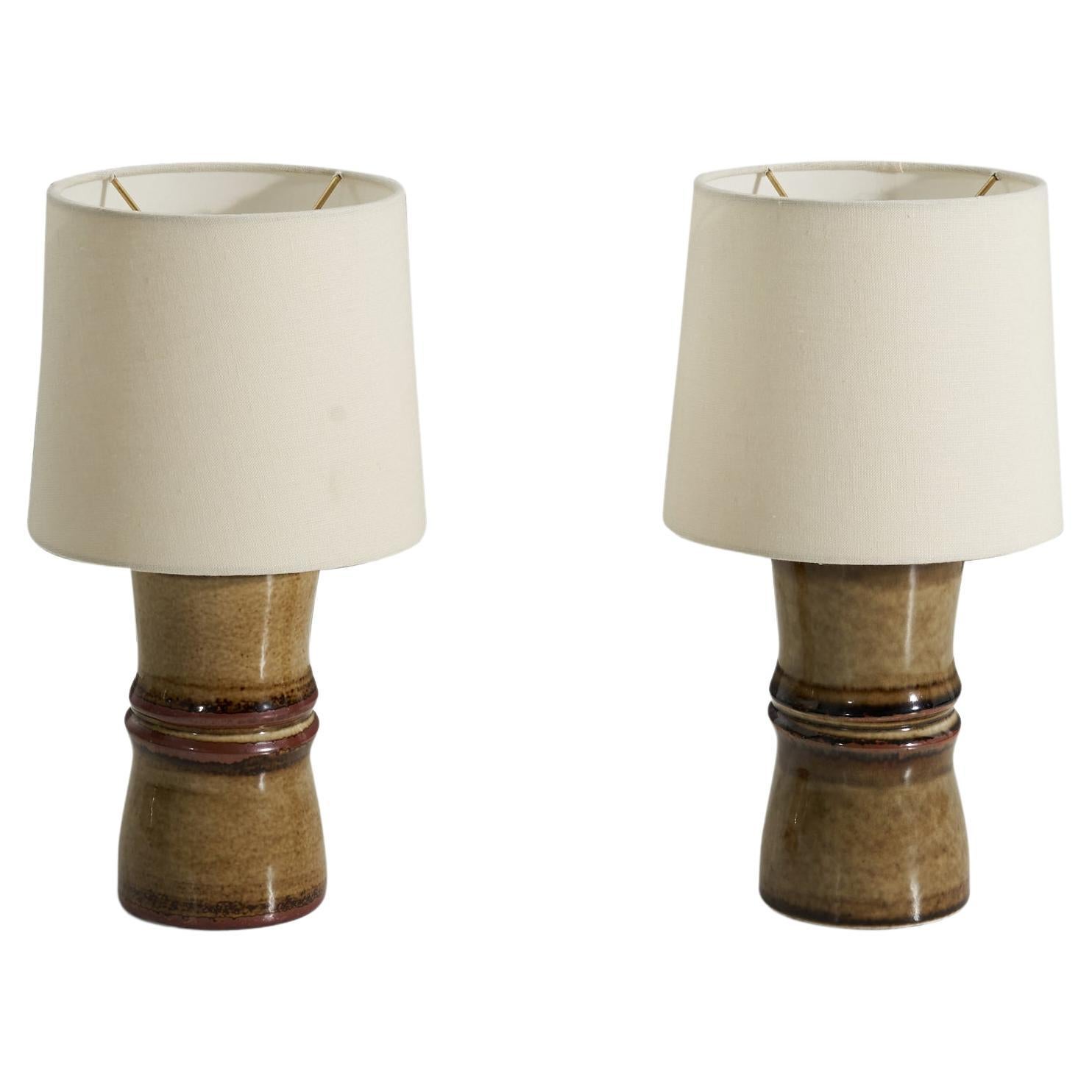 A pair of yellow-brown glazed stoneware table lamps, designed by Olle Alberius and produced by Rörstrand, Sweden, 1960s. 

Sold without lampshades. Measurements listed are of lamps without shades.
For reference:
Measurements of shade (inches) :