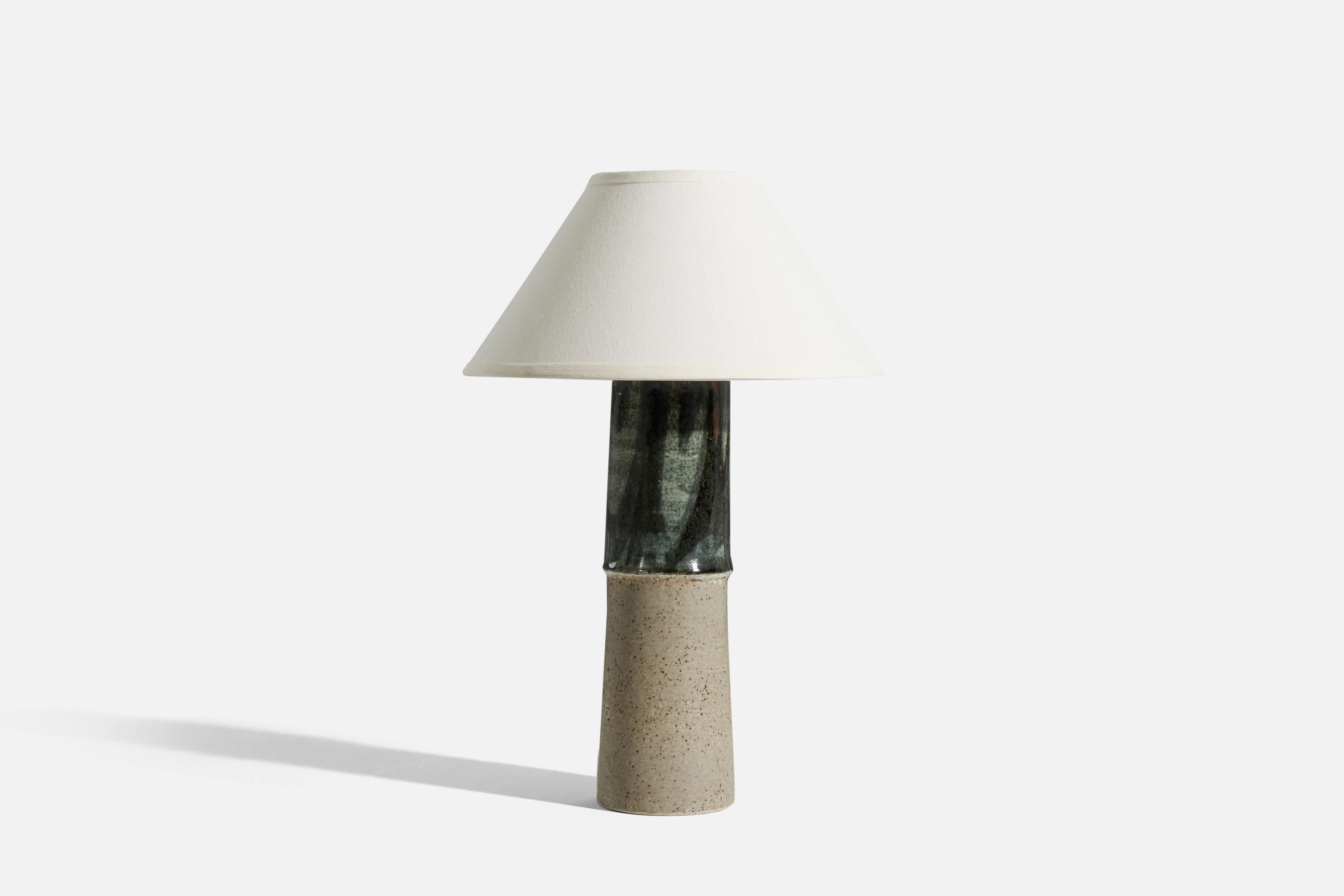 A stoneware and green glazed table lamp, designed by Olle Alberius and produced by Rörstrand, 1960s. 

Sold without lampshade. 
Dimensions of Lamp (inches) : 18.625 x 4.75 x 4.75 (H x W x D)
Dimensions of Shade (inches) : 5.75 x 14 x 8 (T x B x