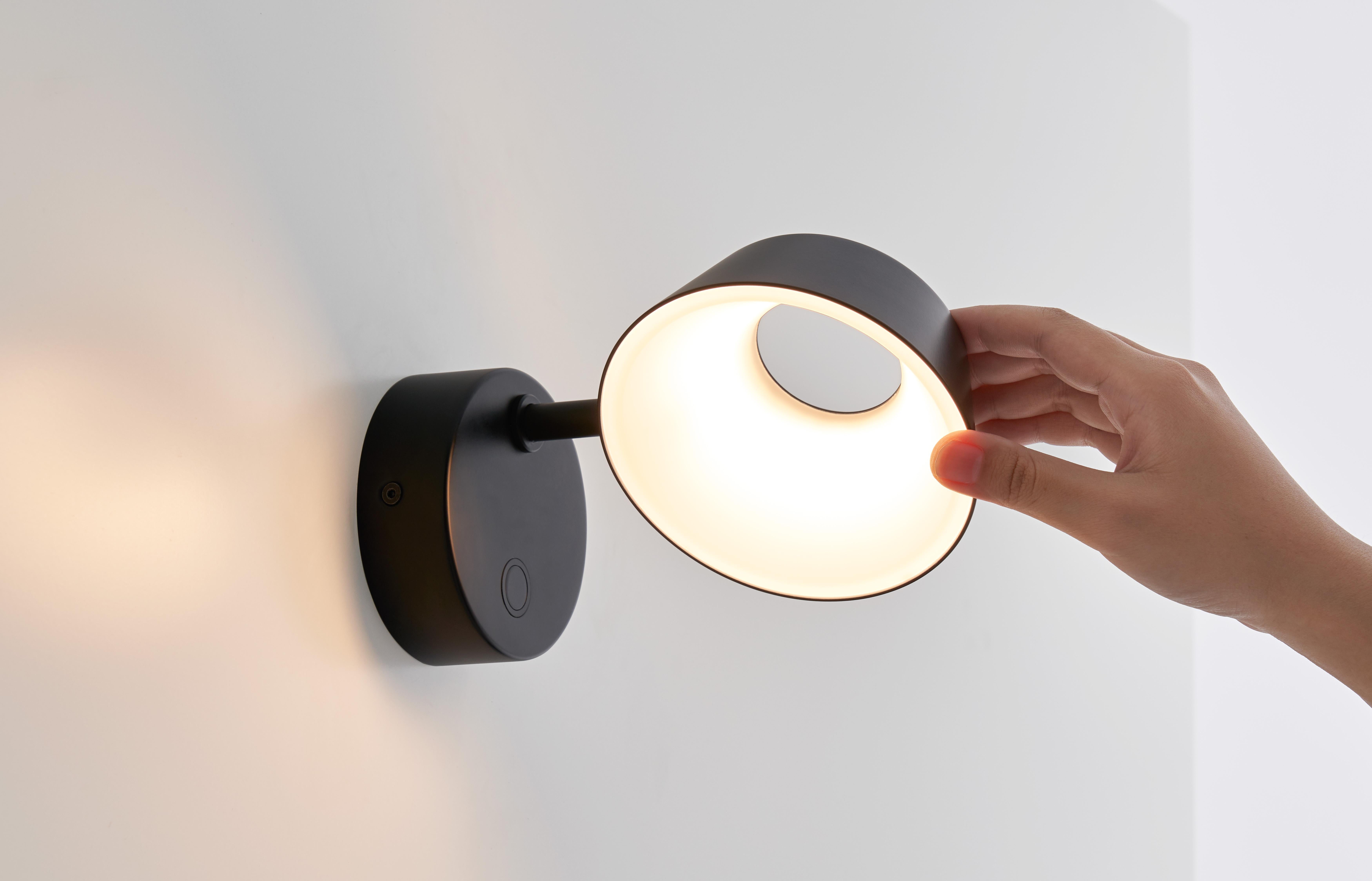 Die Wandleuchte OLO geht immer von einem Kreis oder einer Linie aus. Der drehbare Lampenschirm, eingebettet in das innovative Design eines Hohlkreises mit blendfreier LED-Beleuchtung, kann mit seinem weichen Licht (CRI 90) eindrucksvoll sowohl