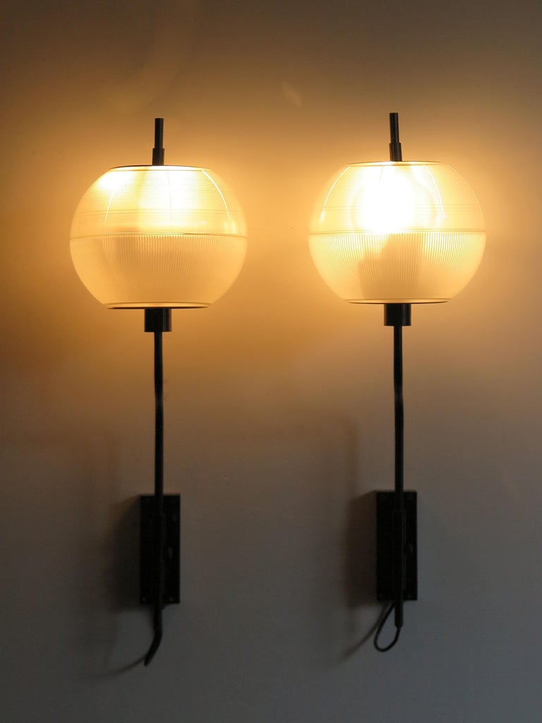 Oluce Italian mid-century sconces wall lamps produced by Oluce from 1960,
burnished brass frame and pressed glass diffusers, adjustable in height, 1960s.