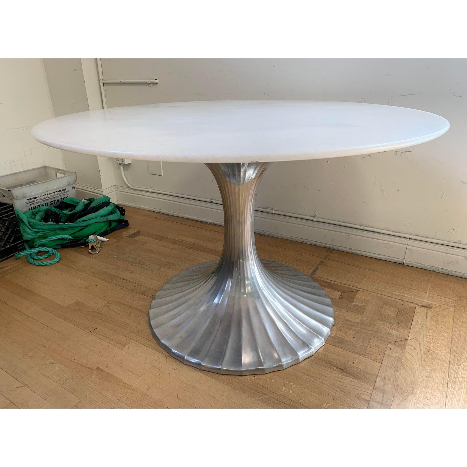 Presents an Oly Studio tulip base table. Cast aluminum base with custom white stone quartz top. A nod to the Classic Mid-Century Modern tulip table but modernized with a touch of glam with the sculptural polished base and ethereal stone top. Minor